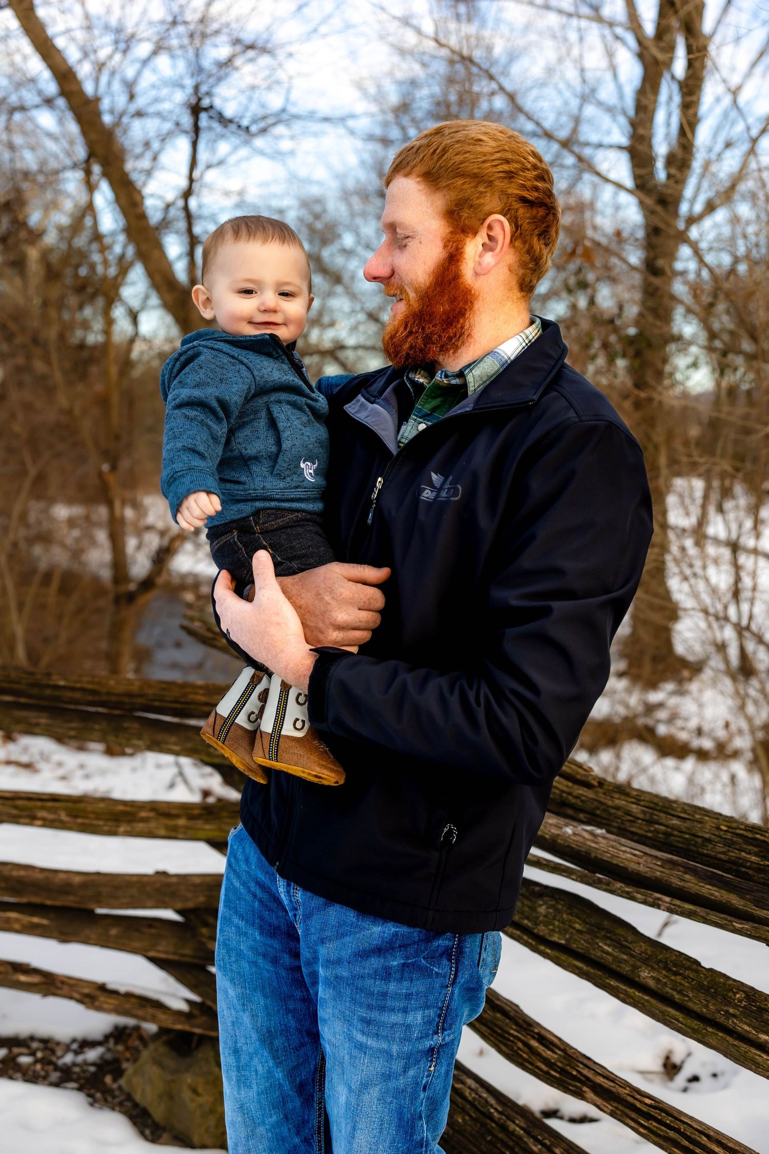 Heartwarming moment between father and child against winter forest backdrop.
