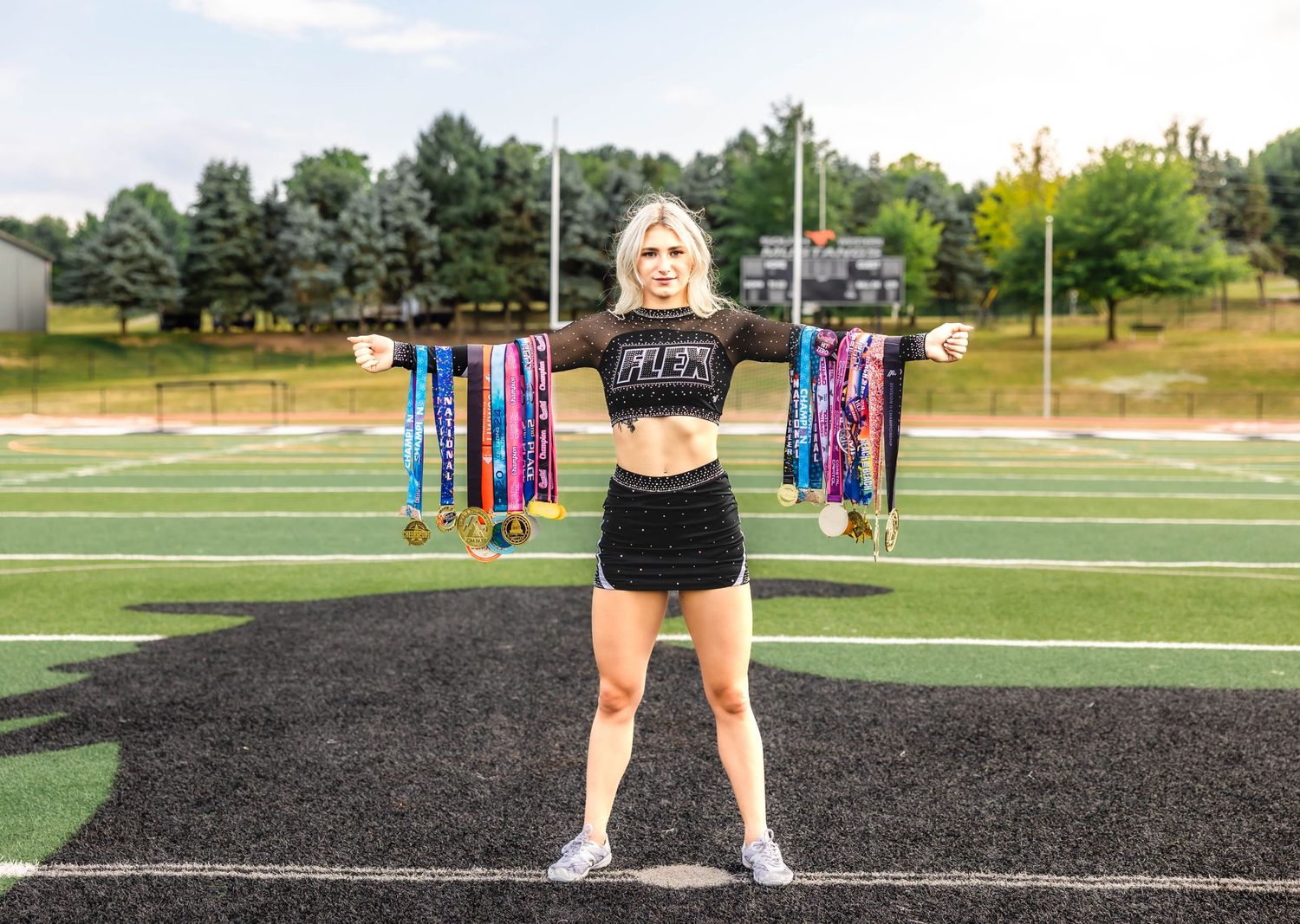 Athletic photo on a sports field displaying colorful medals and trophies.