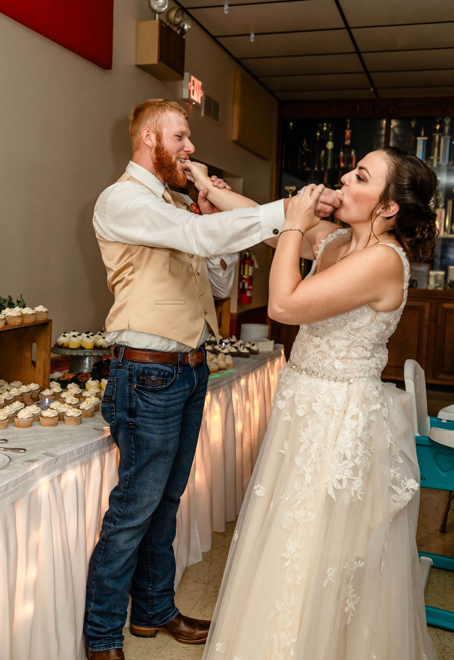A fun cake-feeding moment between the newlyweds at their wedding reception.