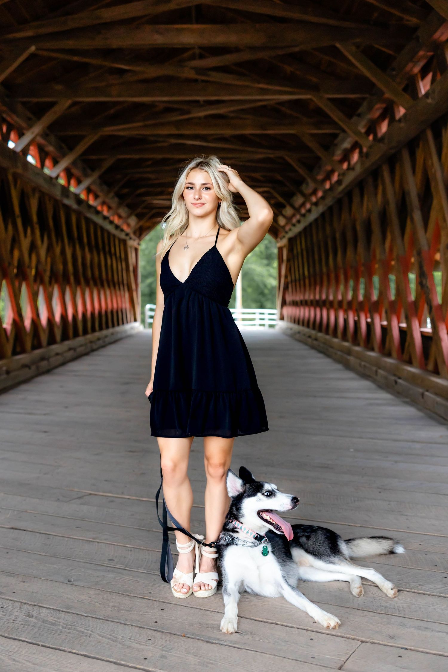 A summer dress and playful husky photographed in a rustic covered bridge setting.