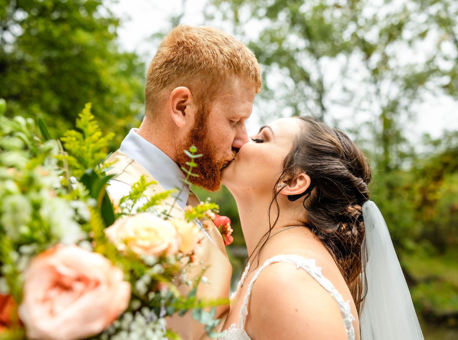 Romantic outdoor wedding portrait moment captured in natural lighting with soft florals.