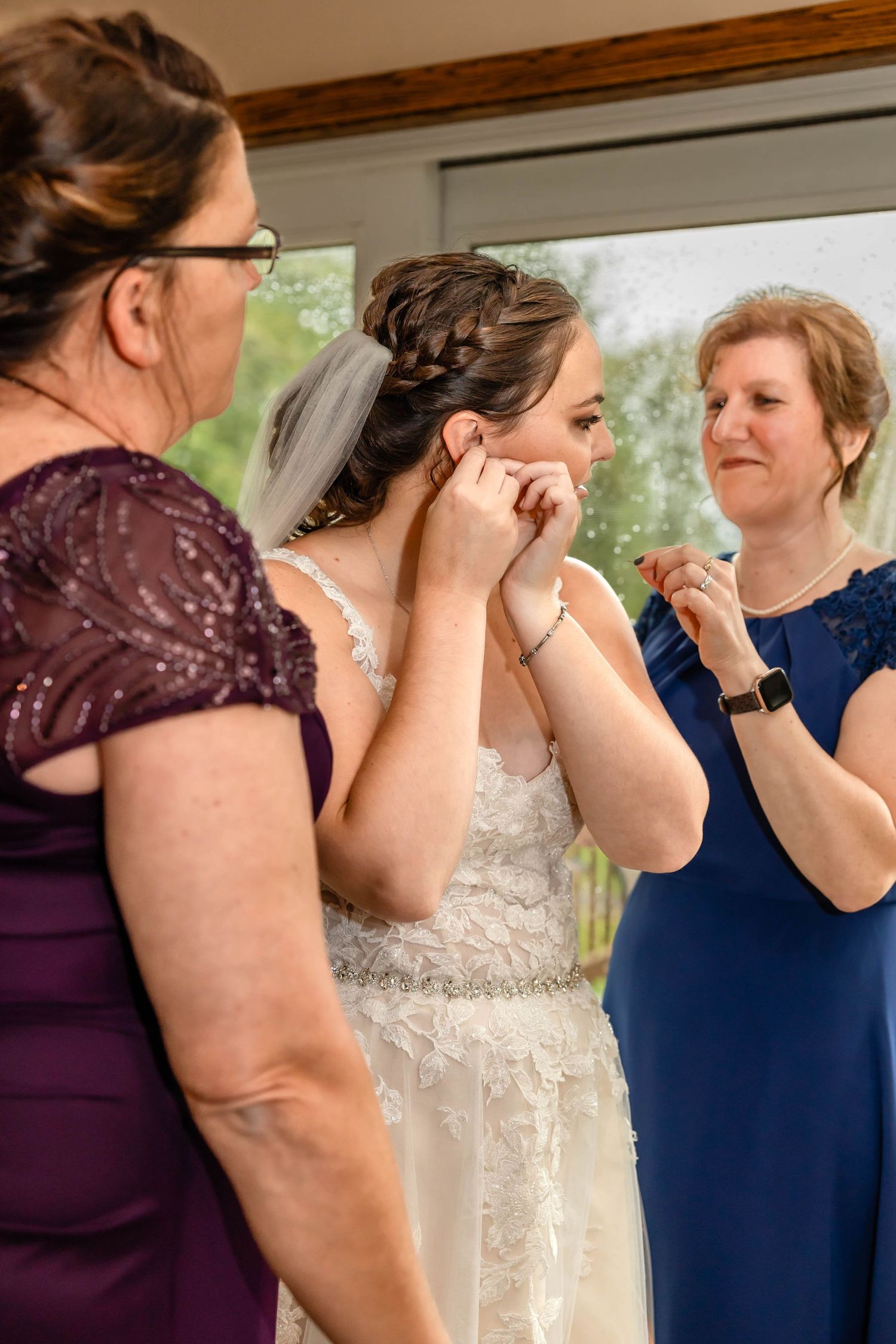 Three women help the bride with final preparations before the ceremony.