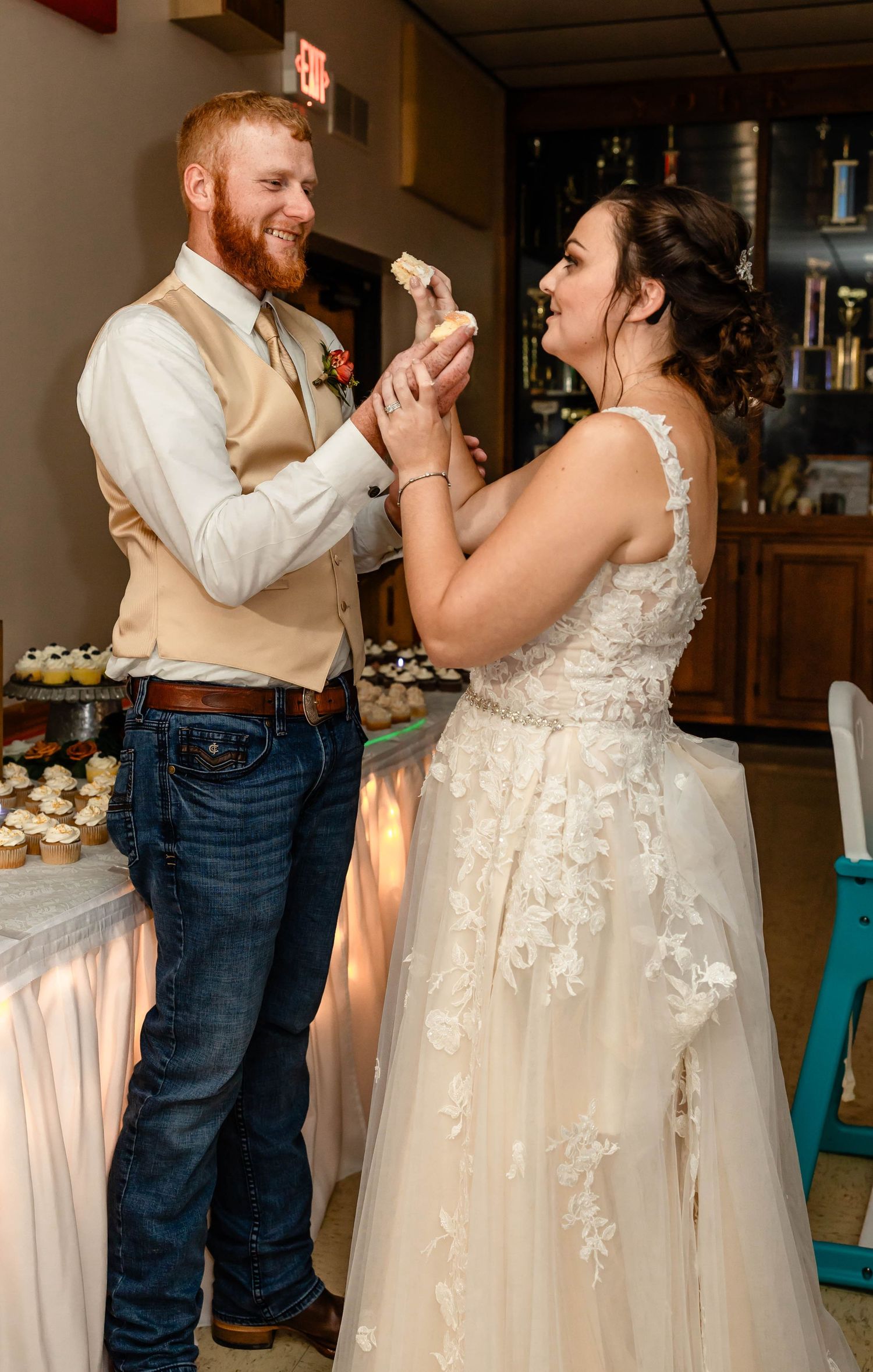The newlyweds share a playful moment while eating wedding cake at their reception.