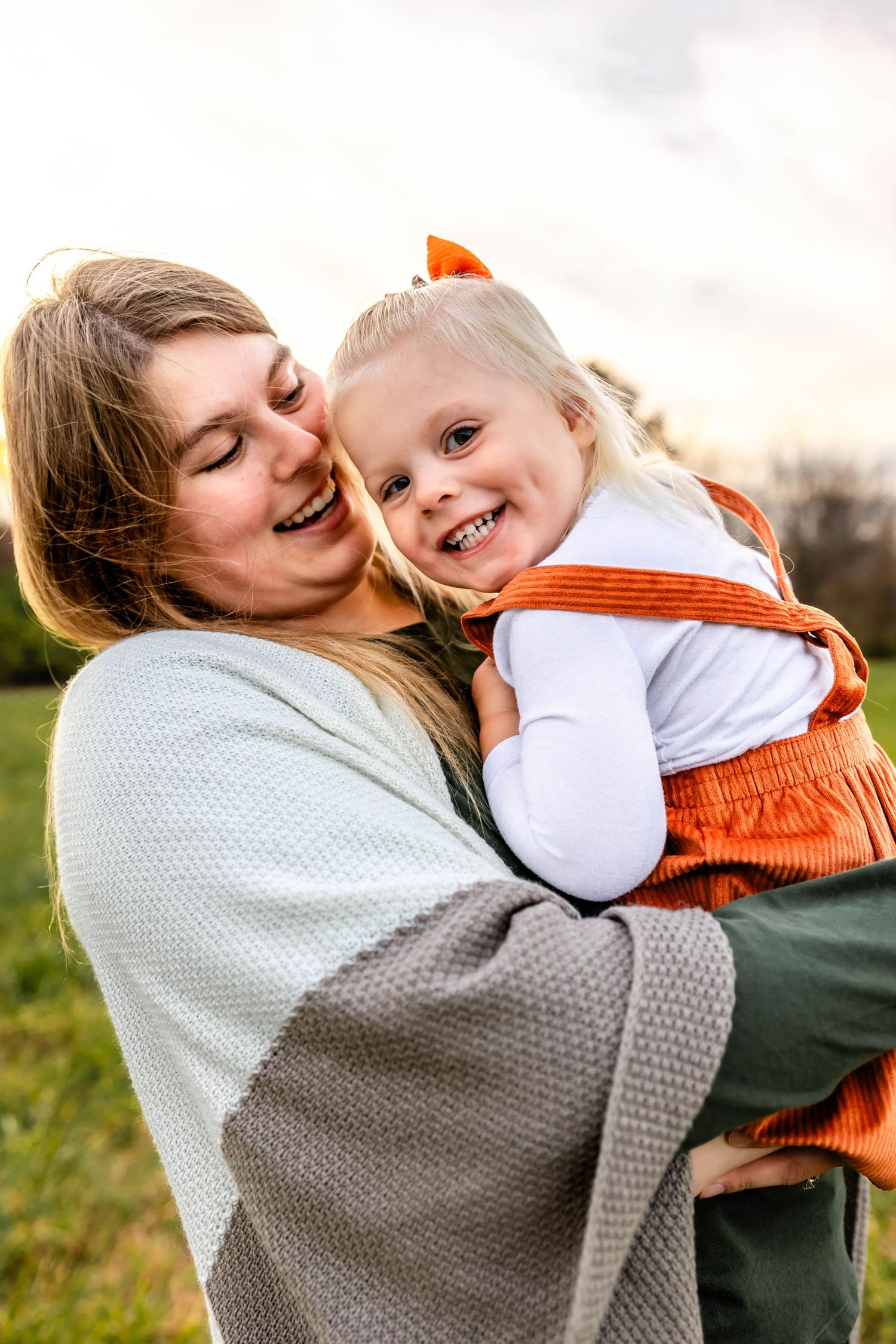 Candid moment of affection between mother and child in outdoor setting.