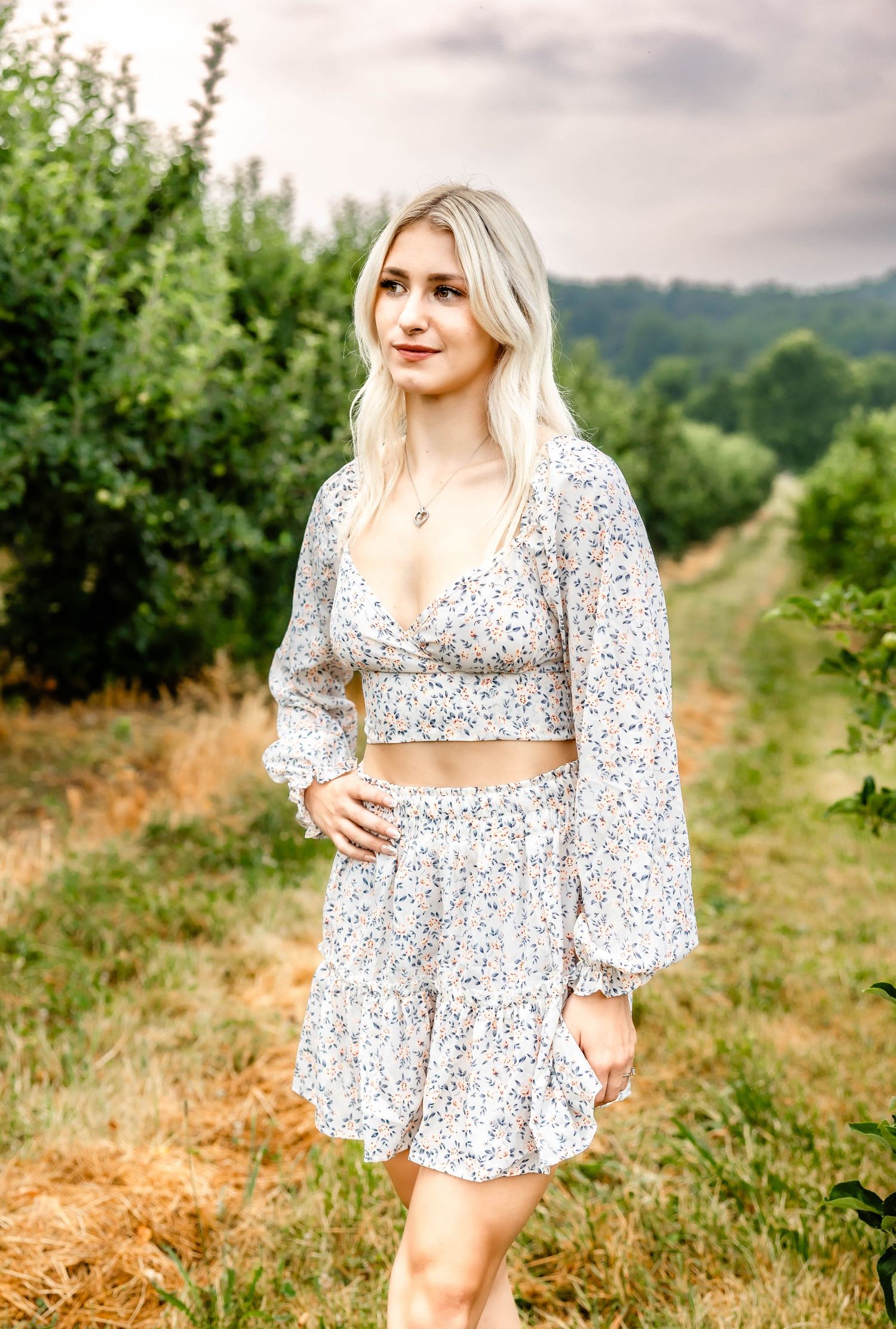 Two-piece floral outfit photographed against rolling hills and greenery.