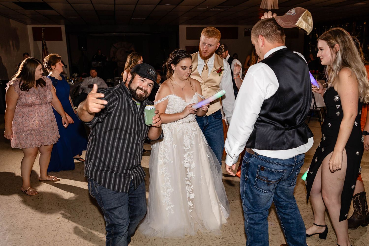 Wedding reception dance circle forms around bride as guests celebrate with dance moves.