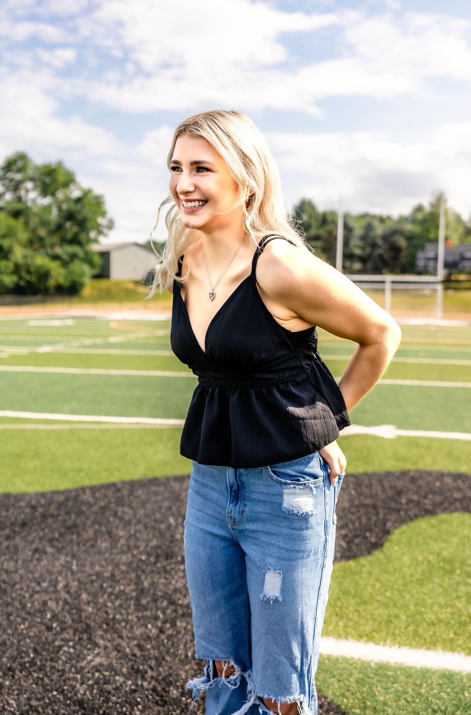 Outdoor fashion photography on a football field showing summery casual style and natural lighting.
