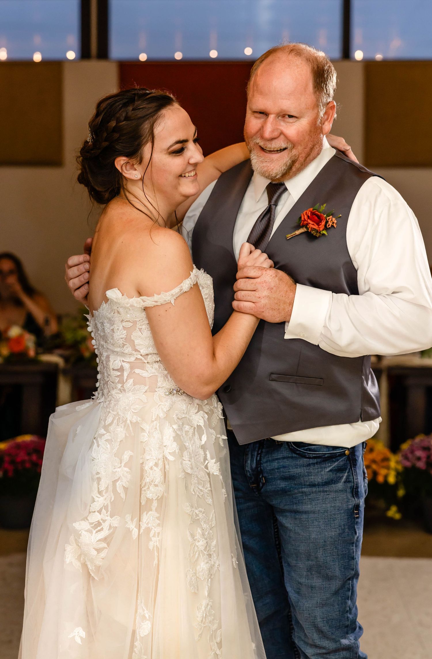A touching dance moment during a wedding reception with rustic decor.