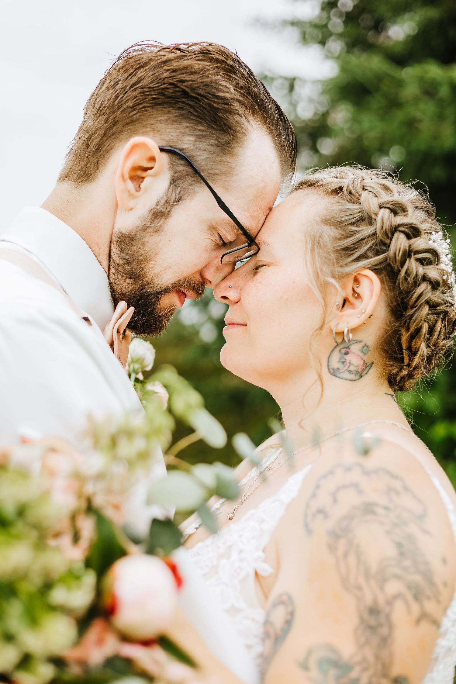 An intimate wedding portrait with garden flowers and natural sunlight.
