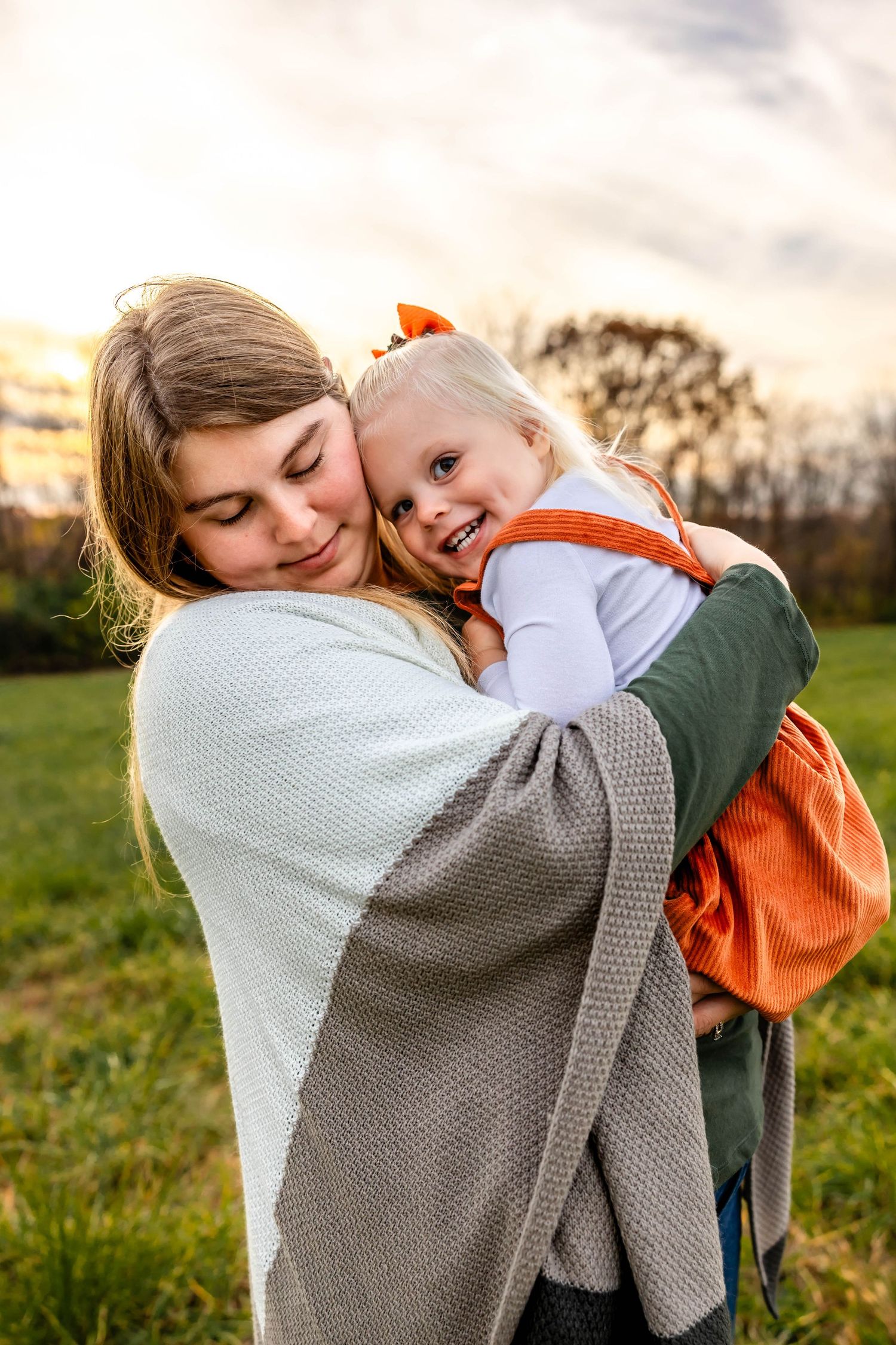 Joyful moment between mother and child outdoors at dusk.