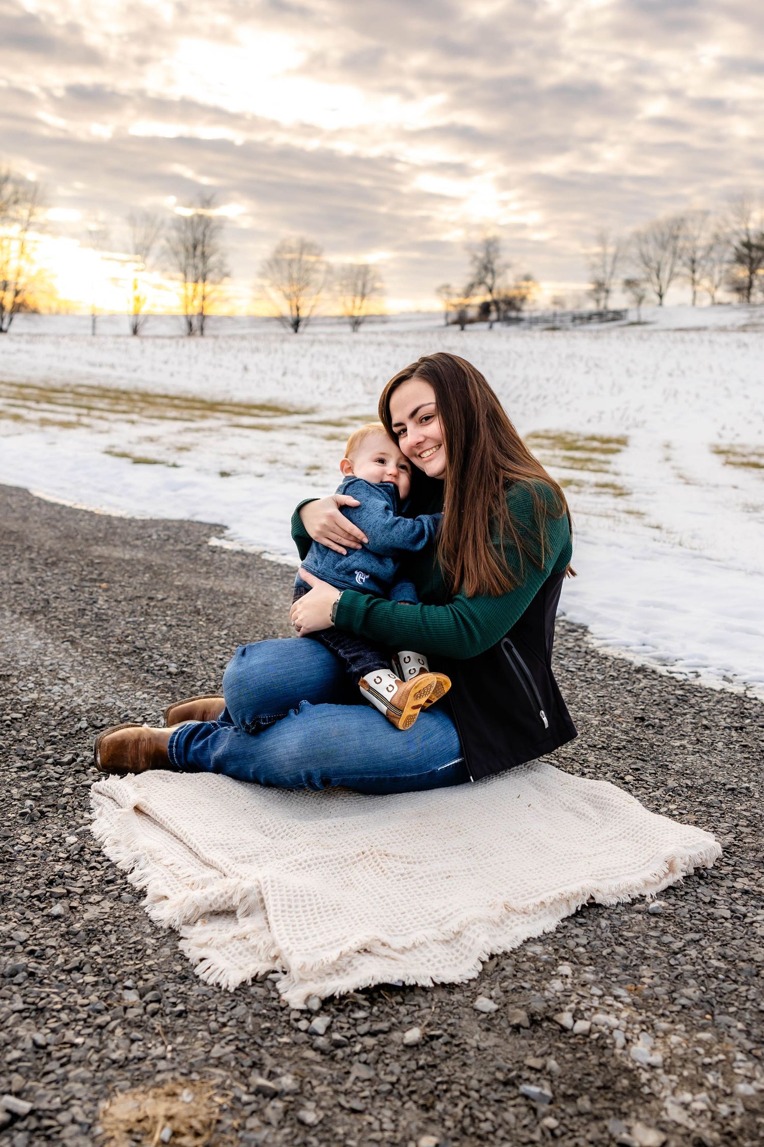 Heartwarming embrace shared on a cozy blanket with snow-covered fields in the background.