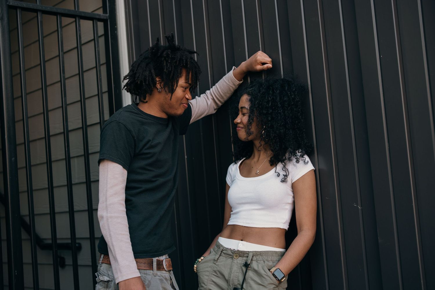 playful black couple laughing together by black industrial wall near Atlantic Station, urban atlanta couples photography session atlanta