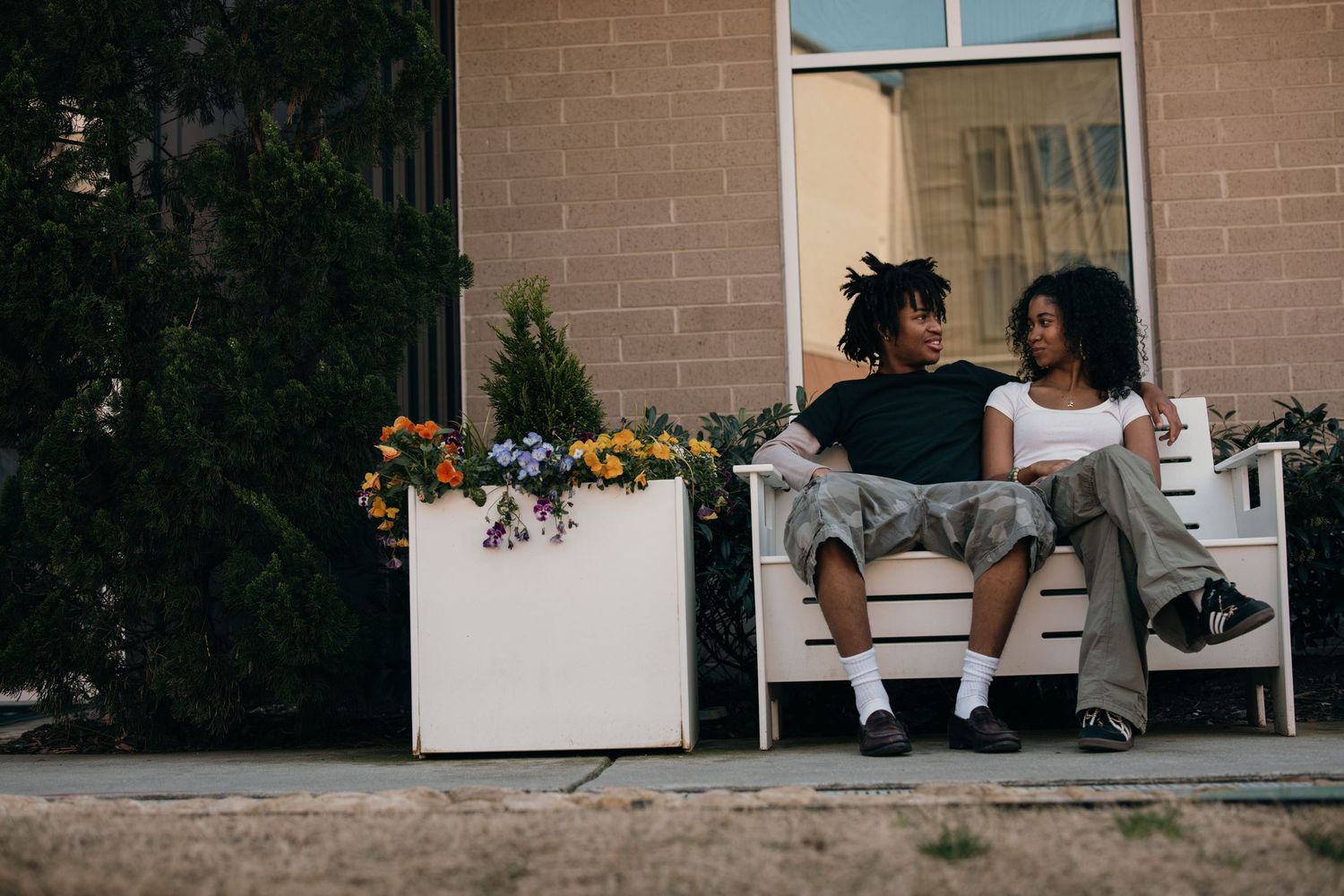 young black couple sitting on a bench surrounded by flowers, Atlantic Station Atlanta couples photography