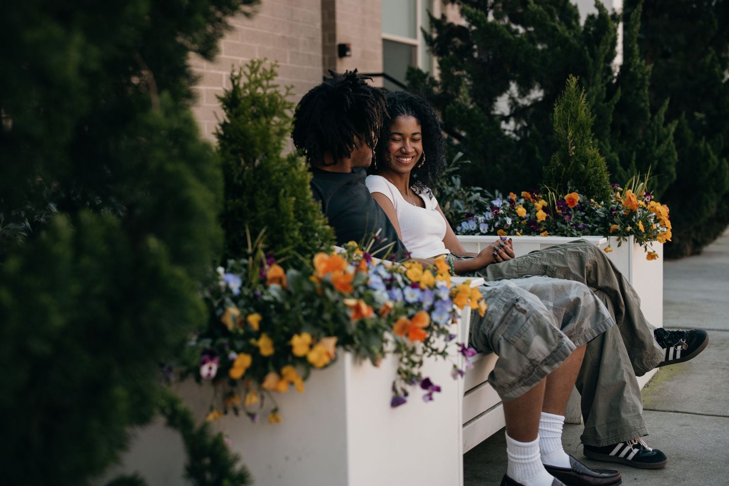 playful young couples sitting on a bench with colorful flowers - atlantic station couples session atlanta, young black couples
