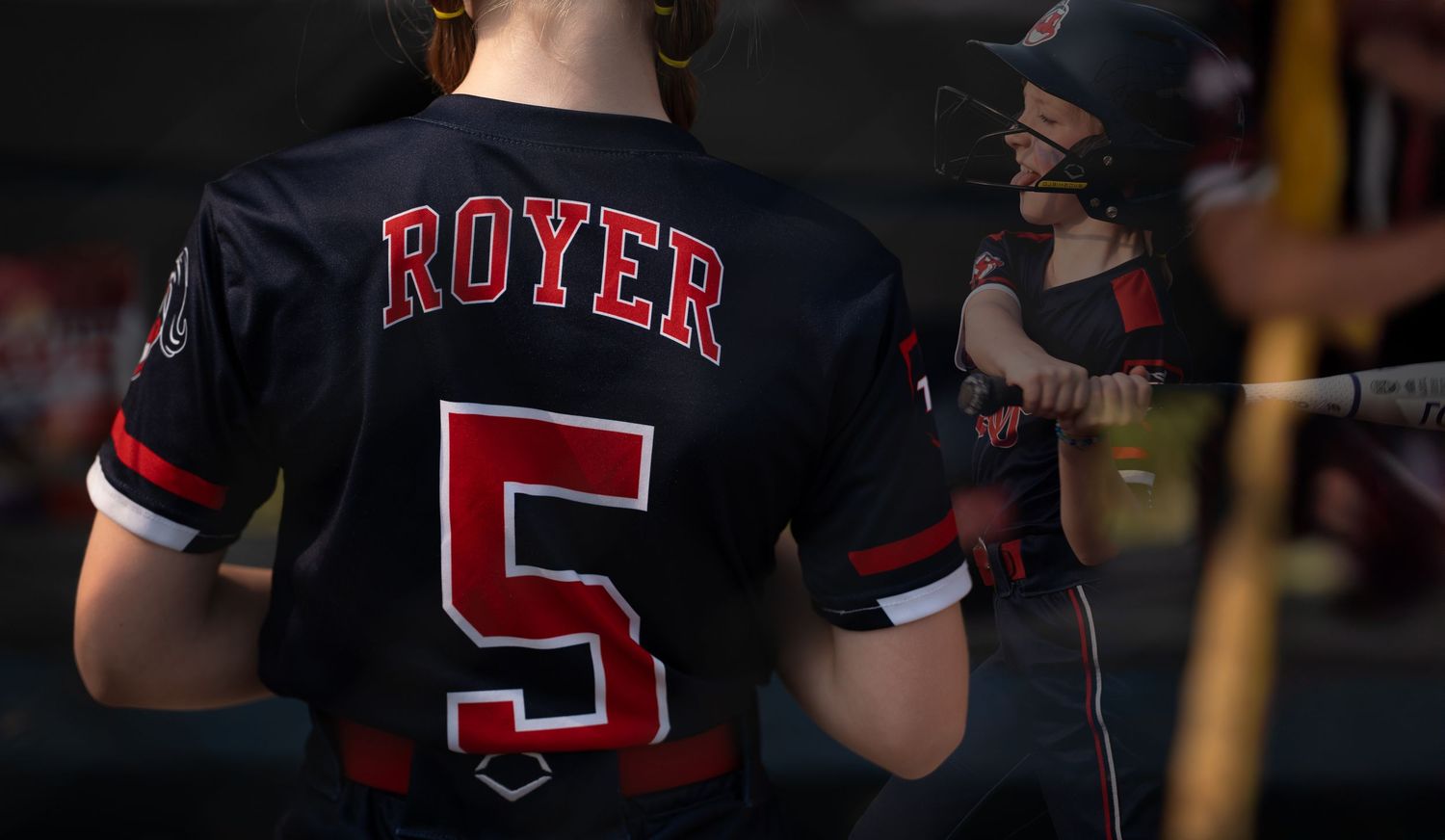 Baseball players in black jerseys with 'Royer' and number 5 on the back.