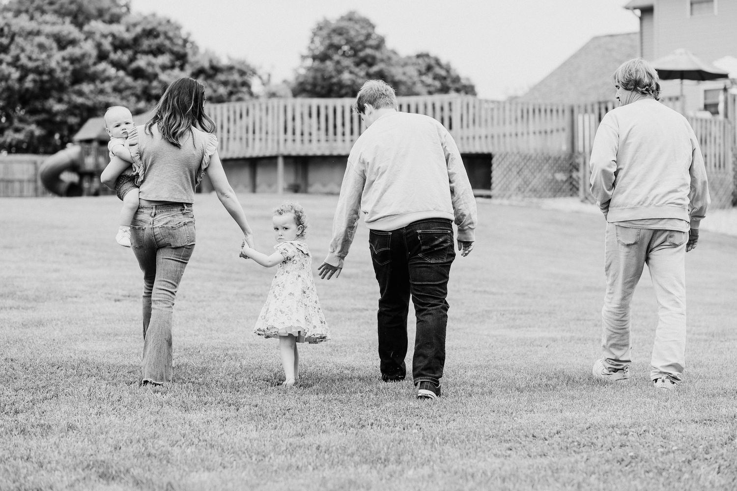 Couple walking hand in hand along a path in black and white photograph.
