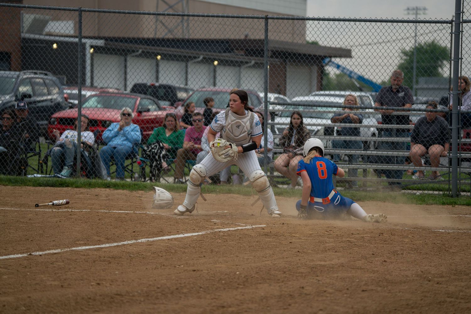 Action shot of runner sliding into base during intense softball game play.