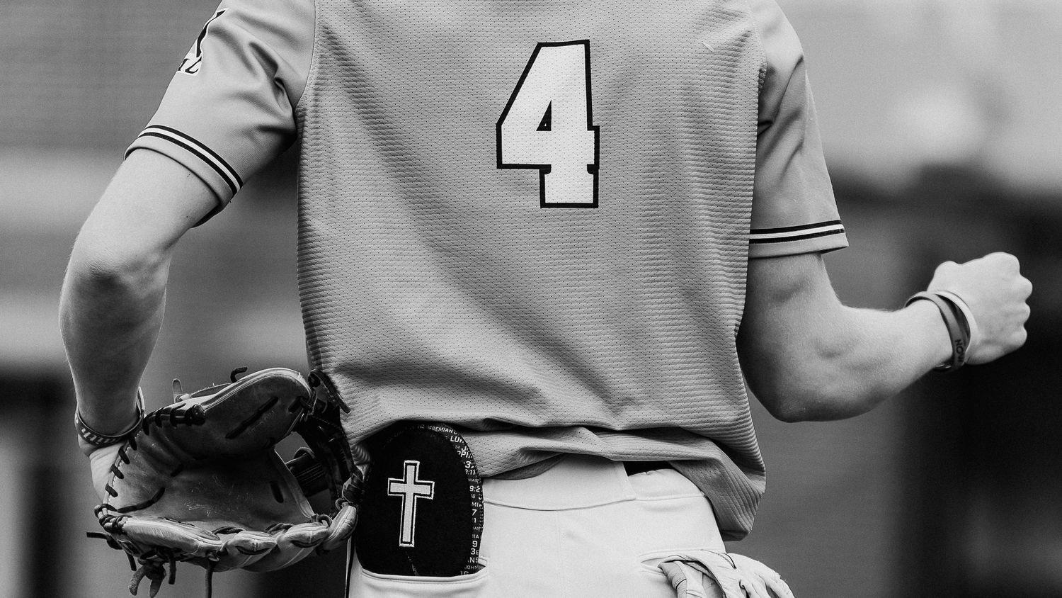 Baseball player wearing jersey number 4 in the dugout.