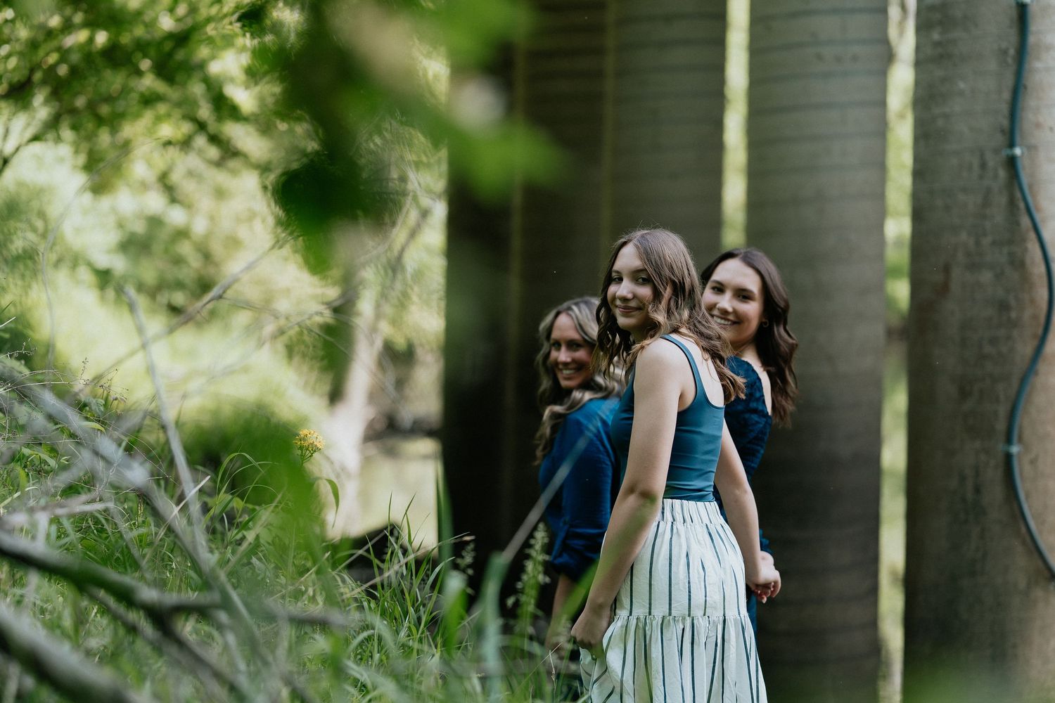 Flowing blue dress captured in sunlit outdoor garden setting.