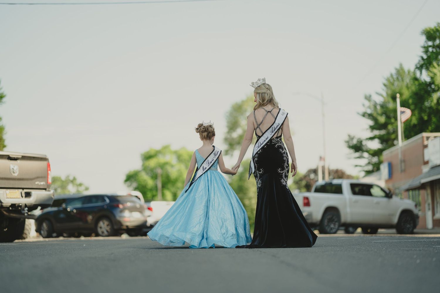 Blue formal dress photographed outdoors against urban backdrop.