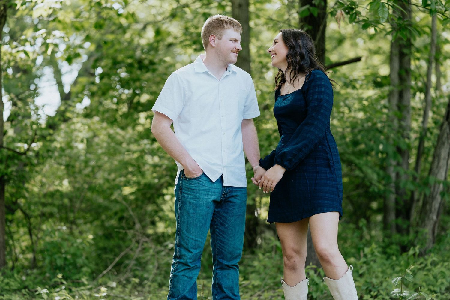Two people walking together on outdoor path surrounded by green foliage.