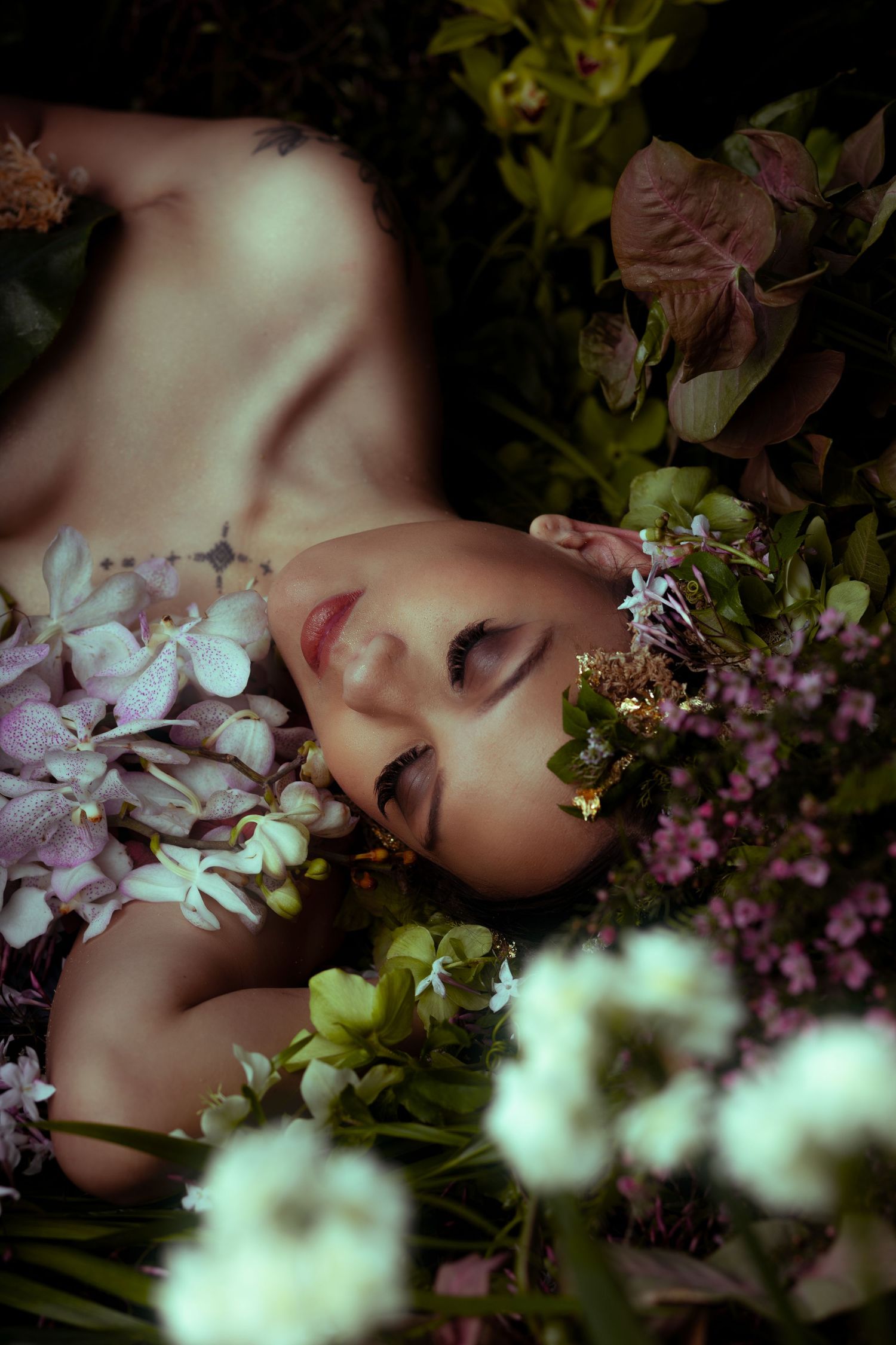Artistic portrait surrounded by delicate purple and white flowers with soft lighting and dreamy atmosphere.