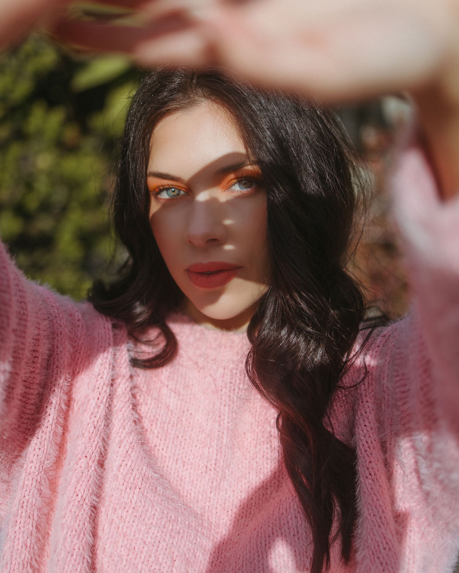 Portrait series in soft lighting showing person in pink knit sweater with glowing sunlit effect.