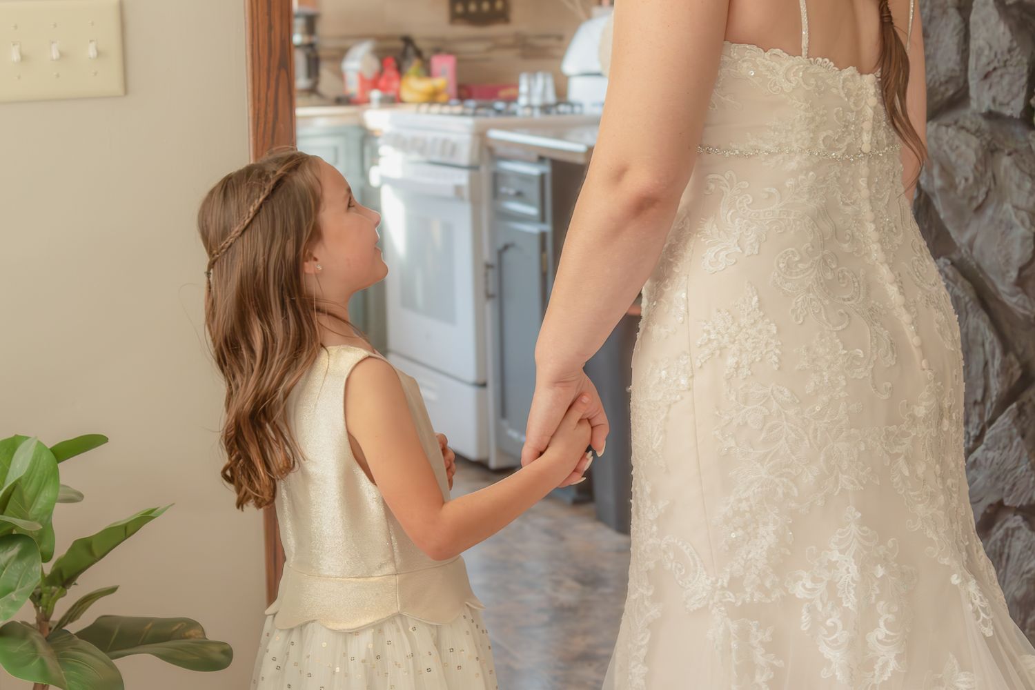 A tender moment showing a young attendant admiring a wedding dress.