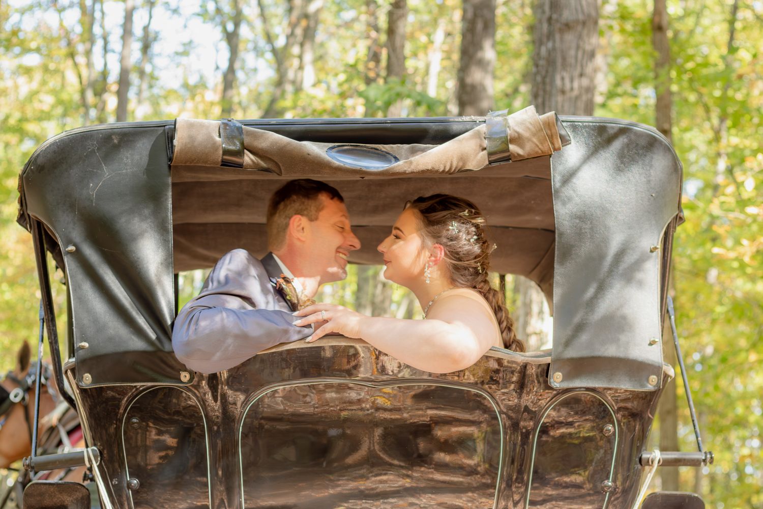 A romantic carriage ride through autumn woods capturing a wedding moment.