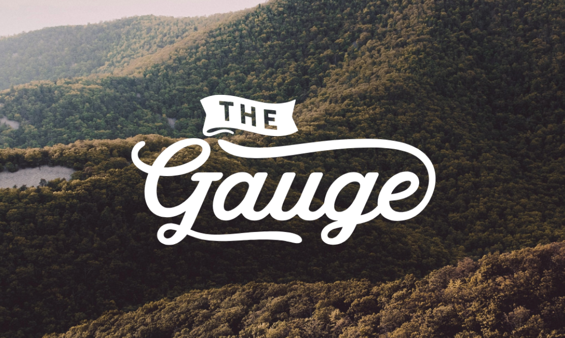 Mountain landscape with white vintage typography overlay creating rustic outdoor branding.