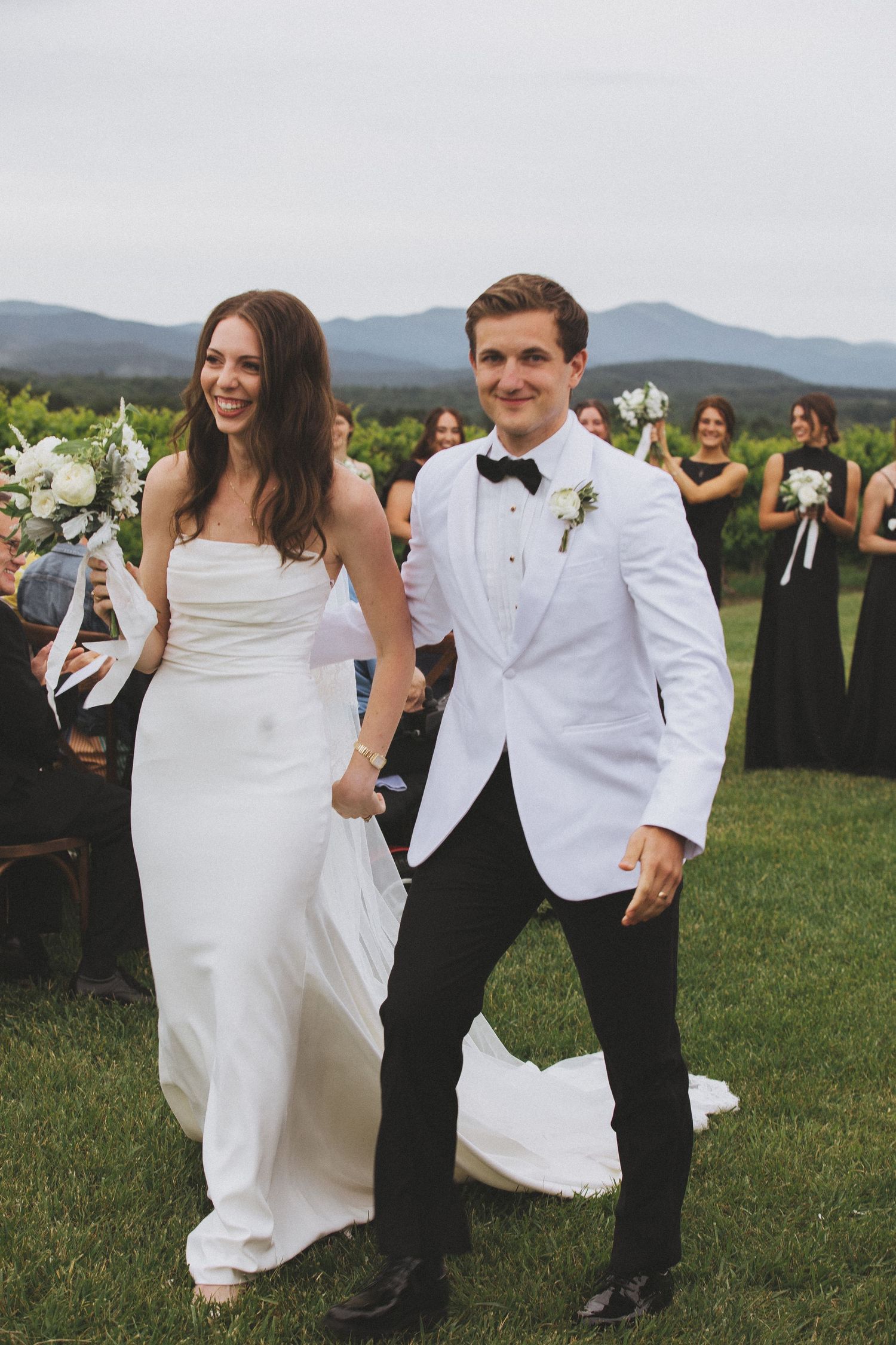 Wedding couple celebrating with guests in front of mountain landscape.