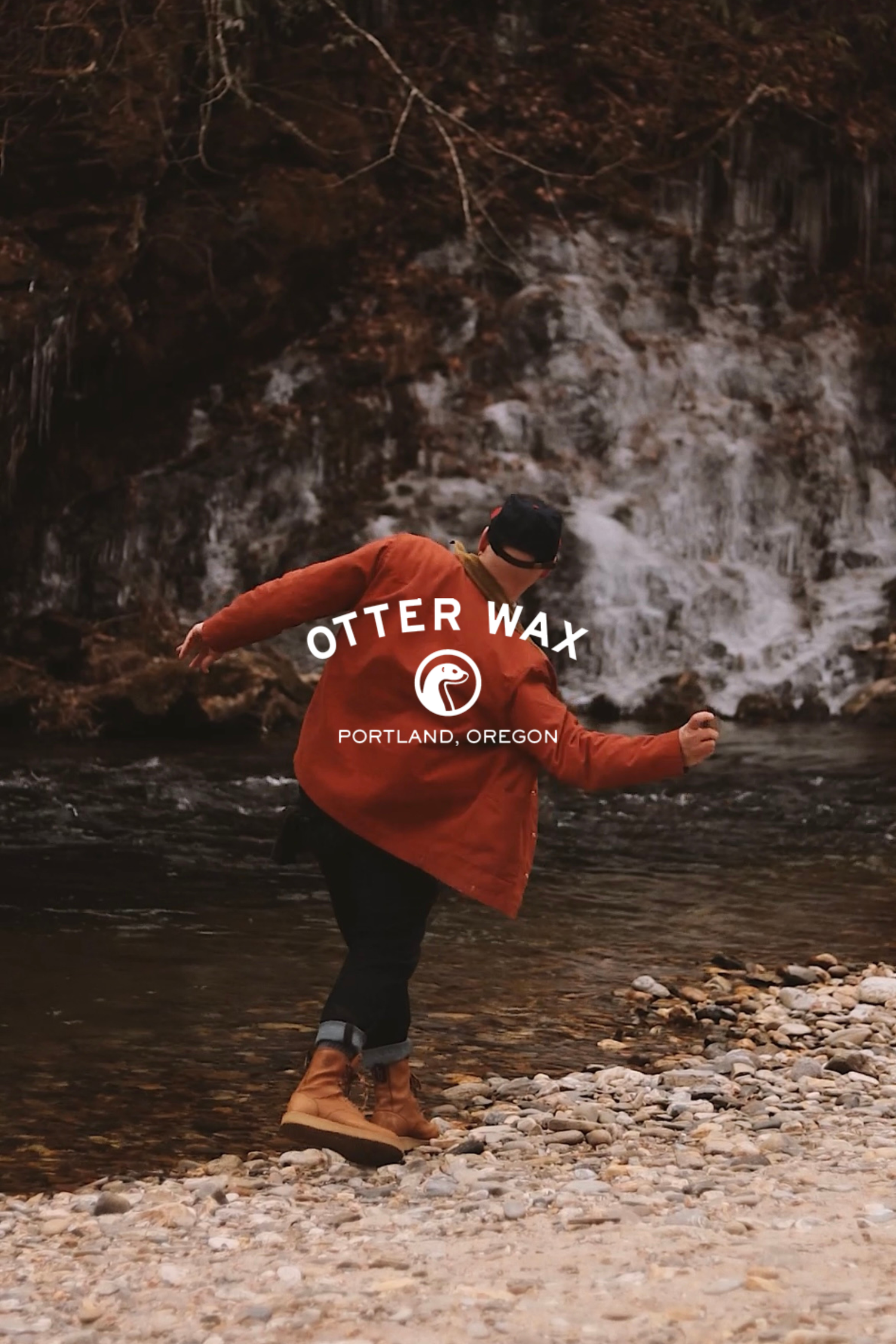Red Otter Wax branded jacket photographed against a misty waterfall backdrop in Portland, Oregon.