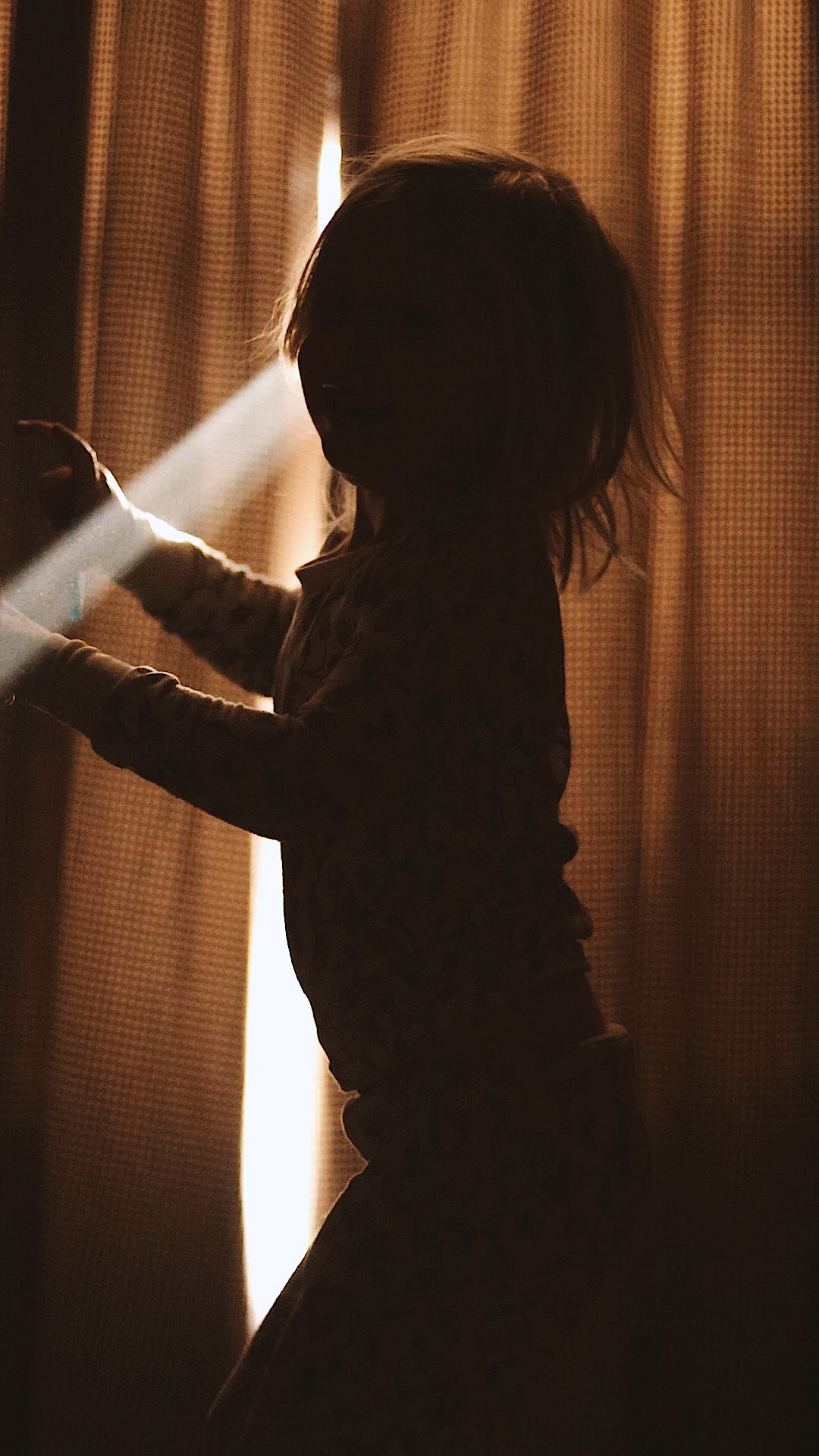 Silhouettes against backlit curtains creating dramatic lighting effect.