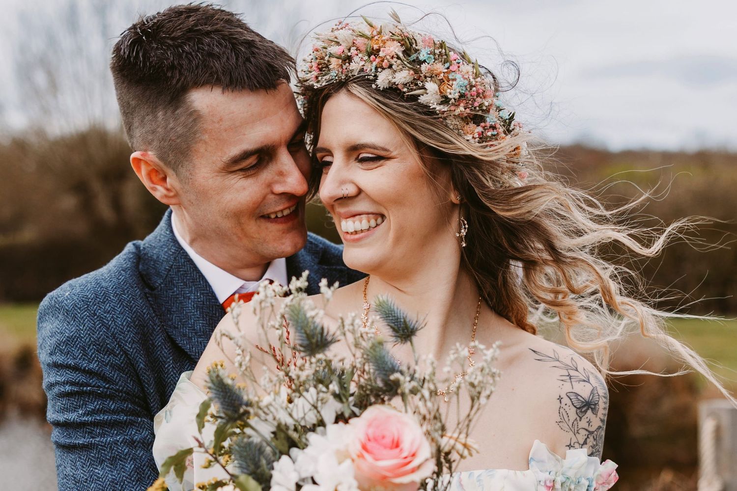 Romantic outdoor wedding photography series showing joyful couple embracing in natural light with floral details.