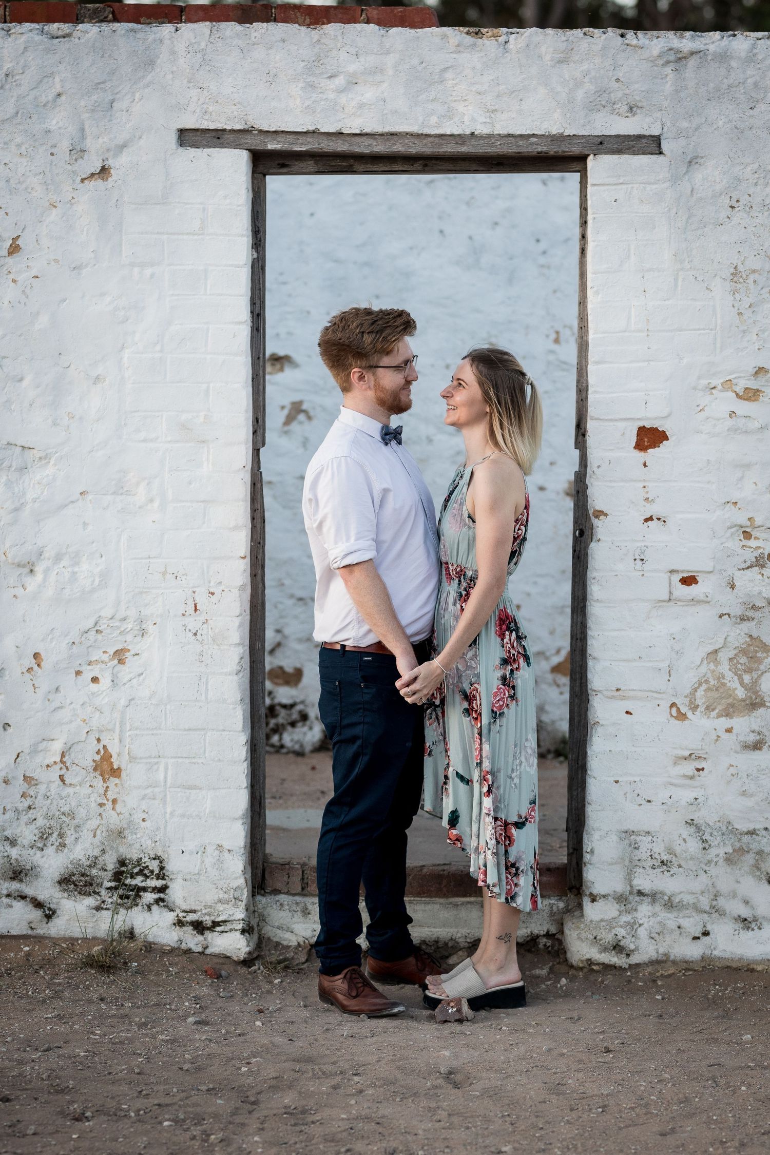 Engaged couple smiling and holding hands during their engagement photo session at perrys paddock celebrating their love