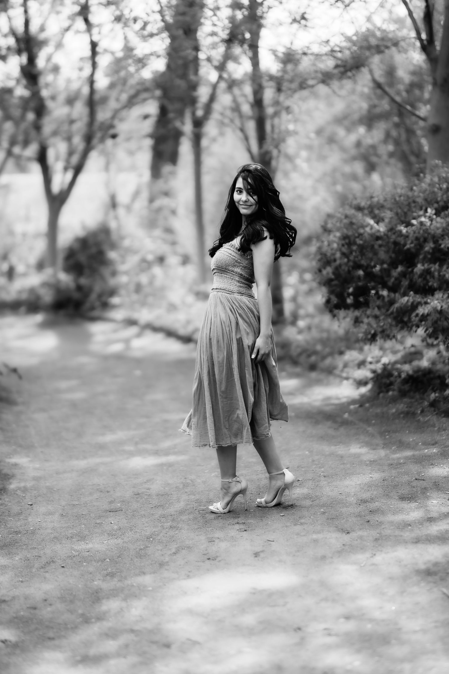 Vintage-style black and white portrait on a garden path with natural lighting.