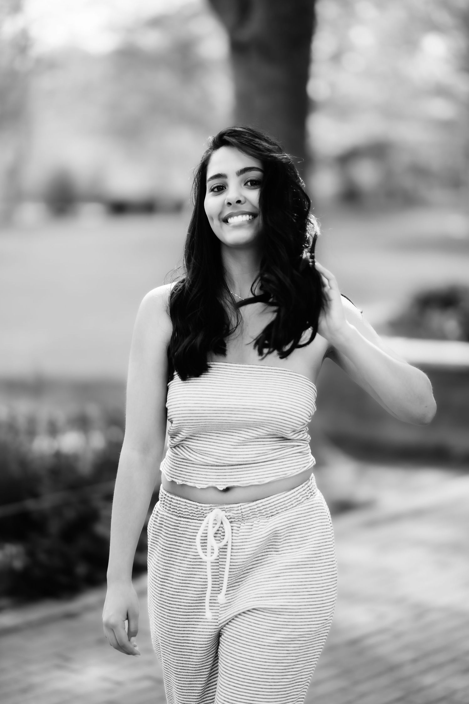 Casual summer portrait in striped loungewear against a blurred outdoor background.