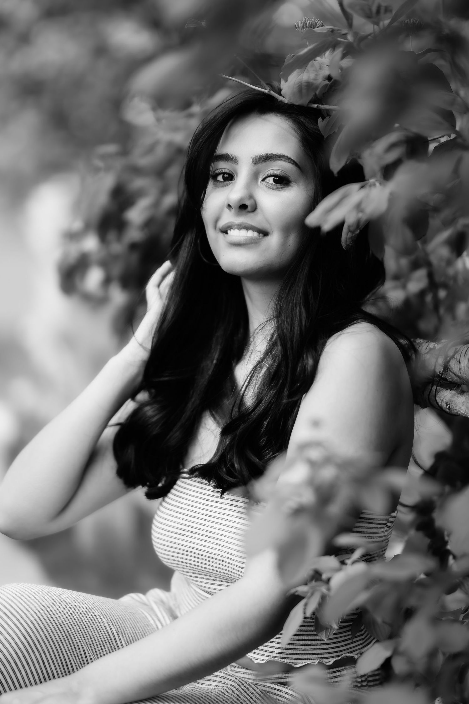 Relaxed outdoor portrait in striped casual wear with soft natural lighting.