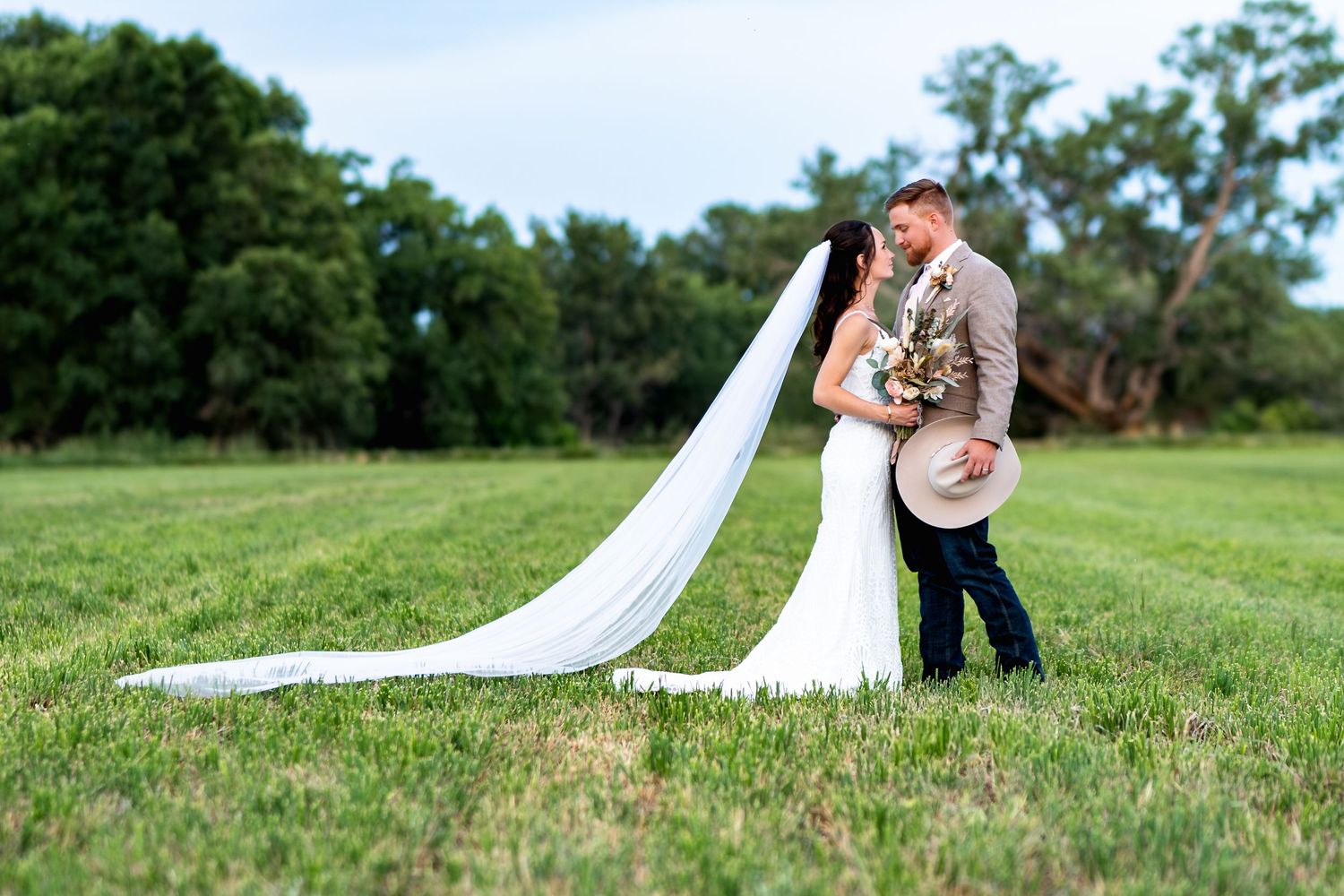 A romantic dip pose captured during wedding portraits in a scenic outdoor setting.