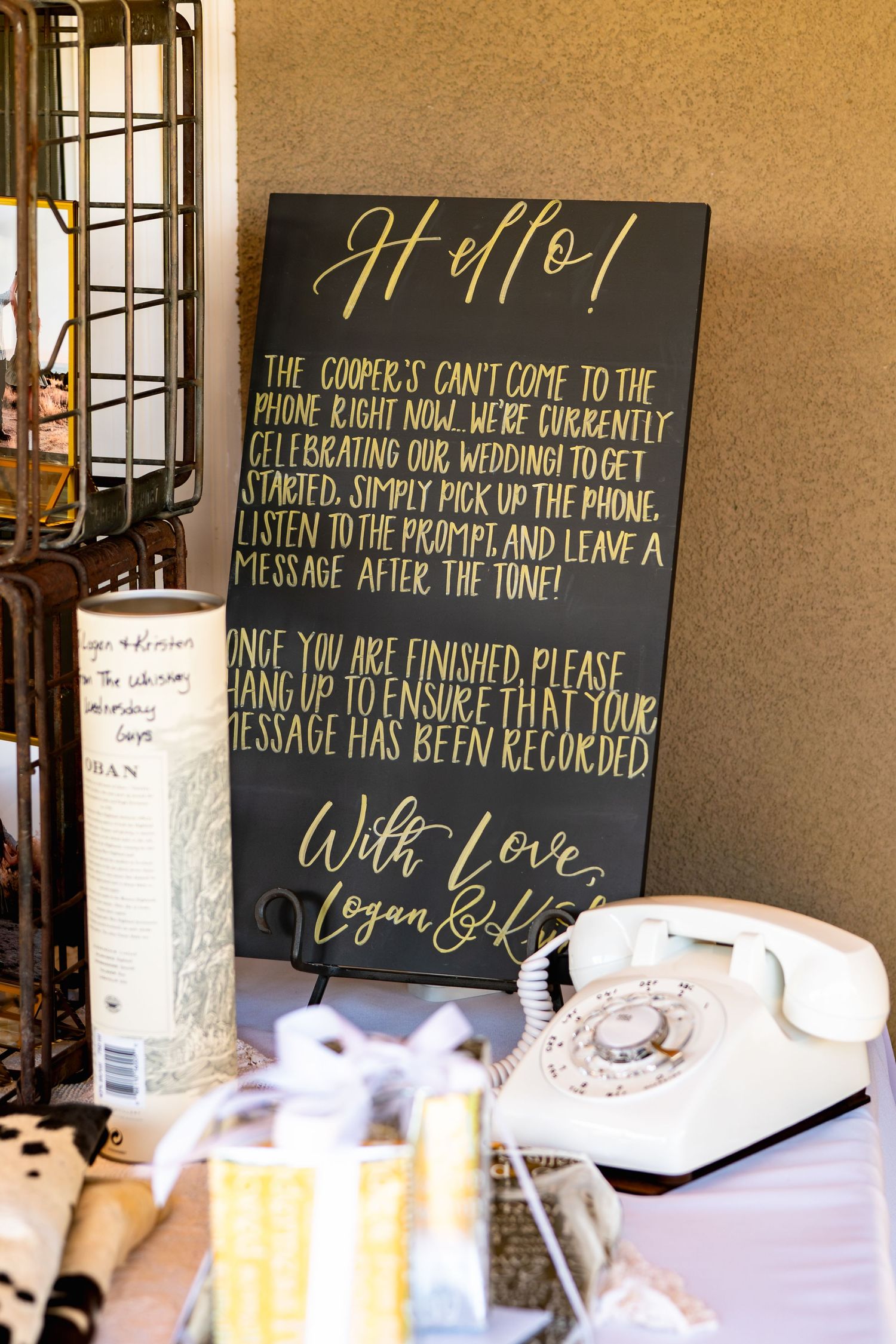 Vintage white telephone next to welcome sign with instructions for virtual guests at wedding reception.