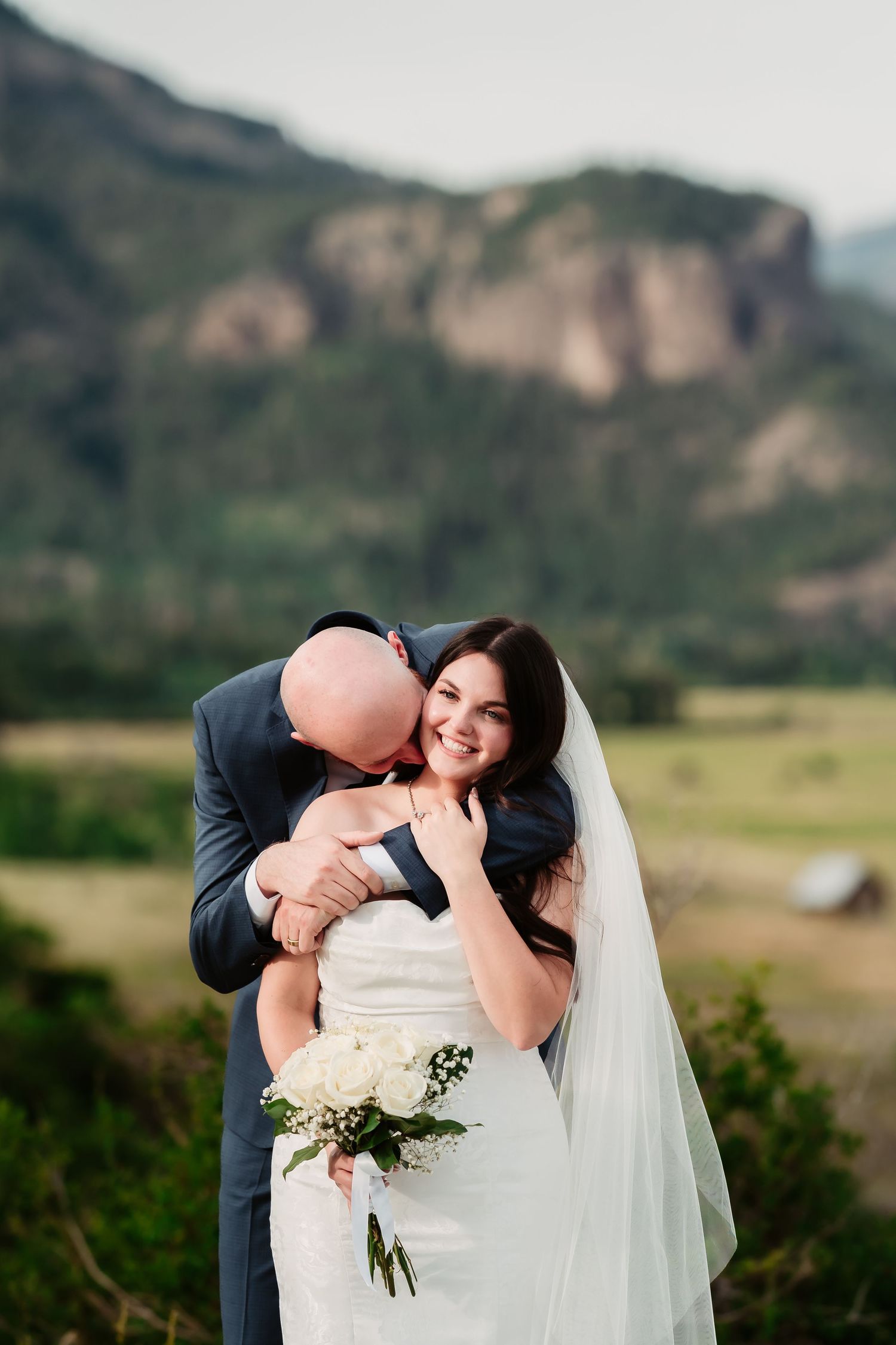 A romantic wedding moment captured against a scenic mountain backdrop.