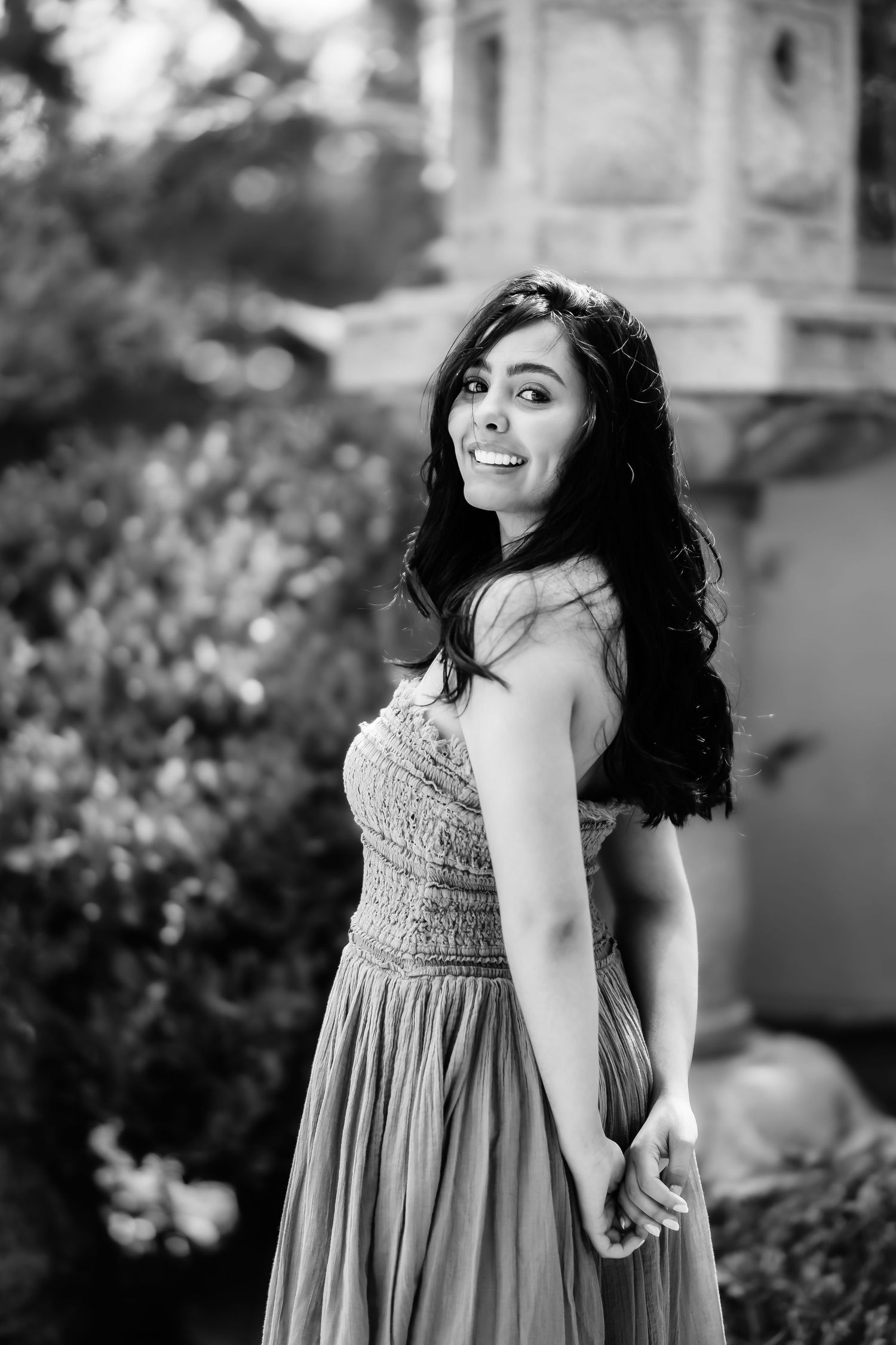 Black and white portrait of woman in strapless dress with flowing hair.