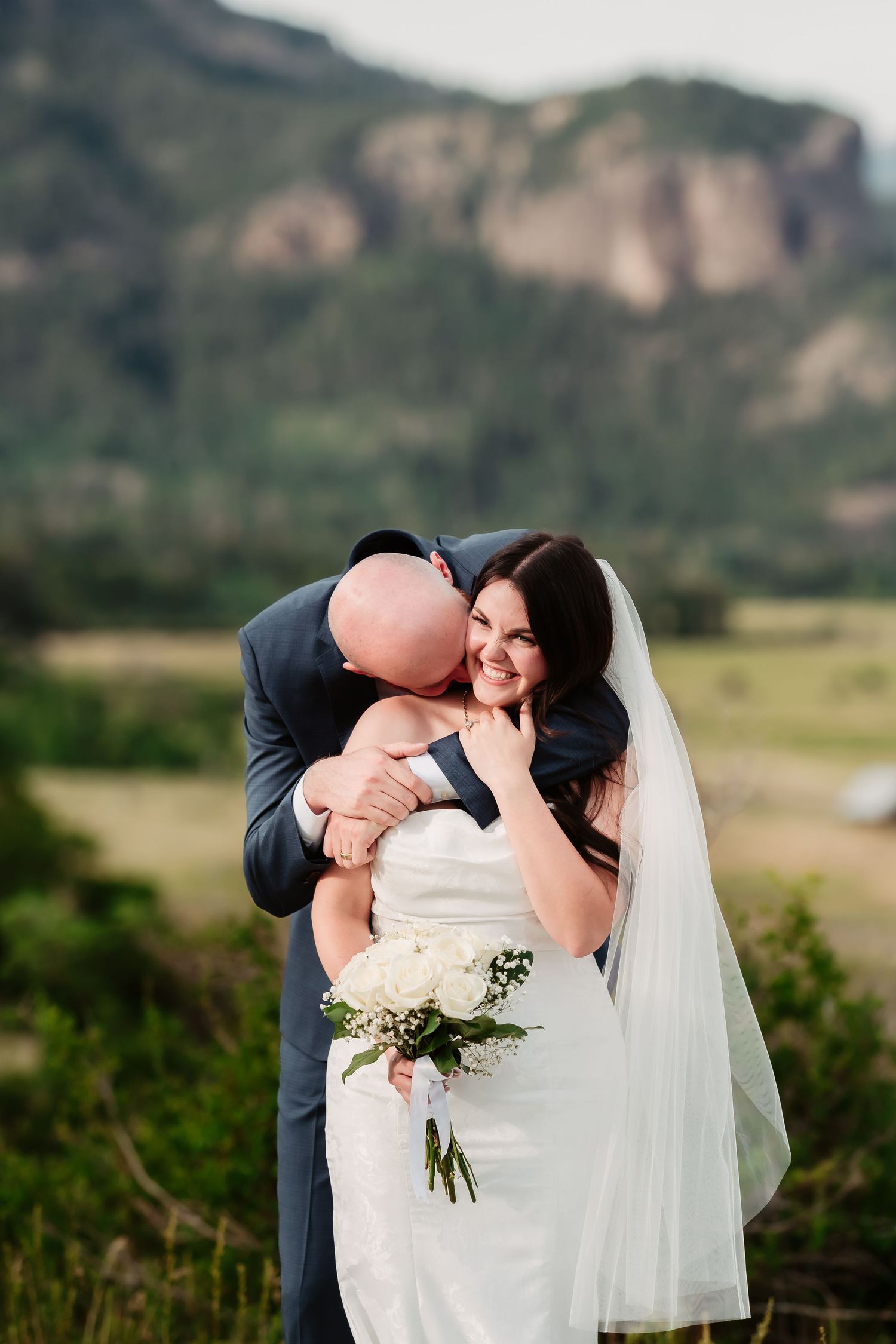 A romantic wedding moment captured against majestic mountain scenery.