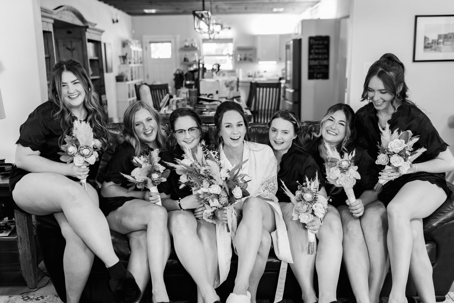 Bridal party in matching robes poses together during pre-wedding preparations.