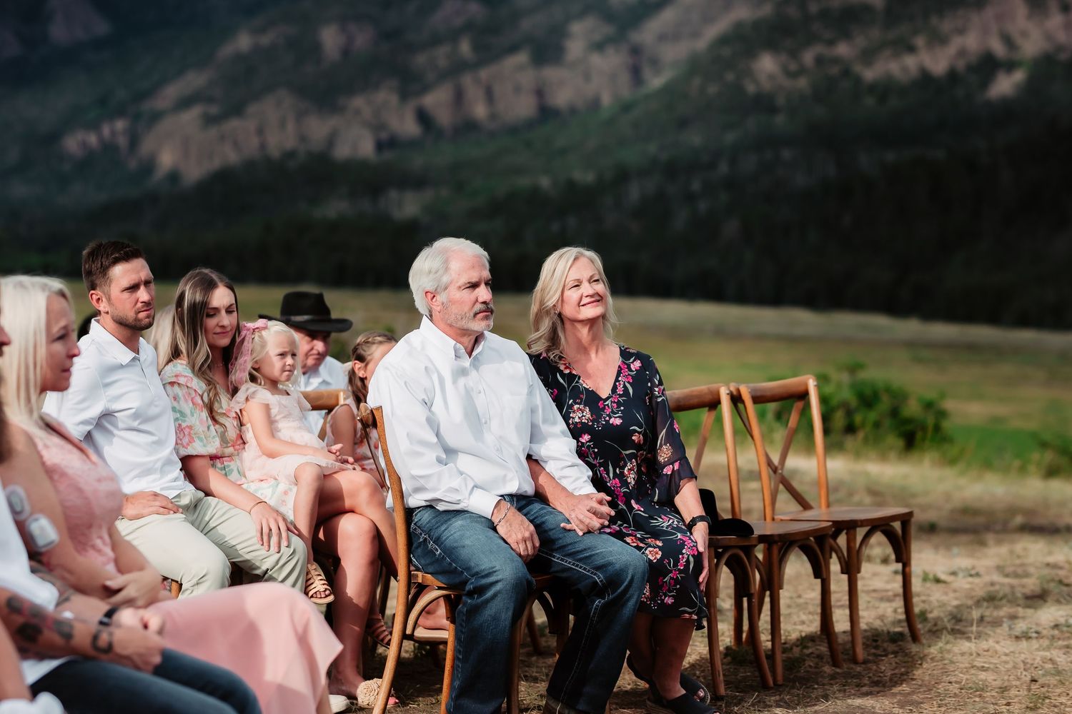 Mountain landscape with wedding ceremony seating arranged outdoors.
