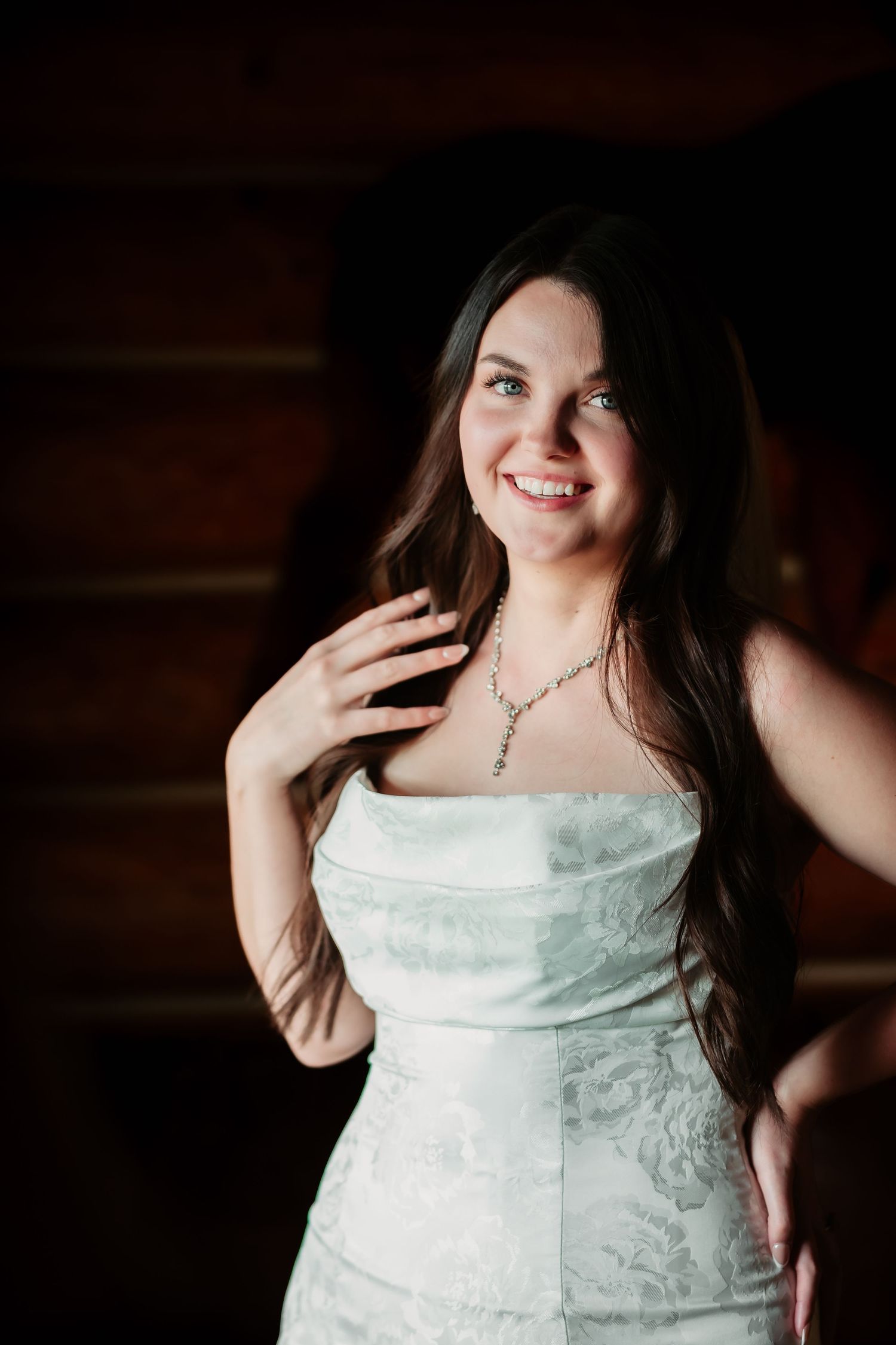 A joyful moment captured in a strapless white floral dress against a dark background.