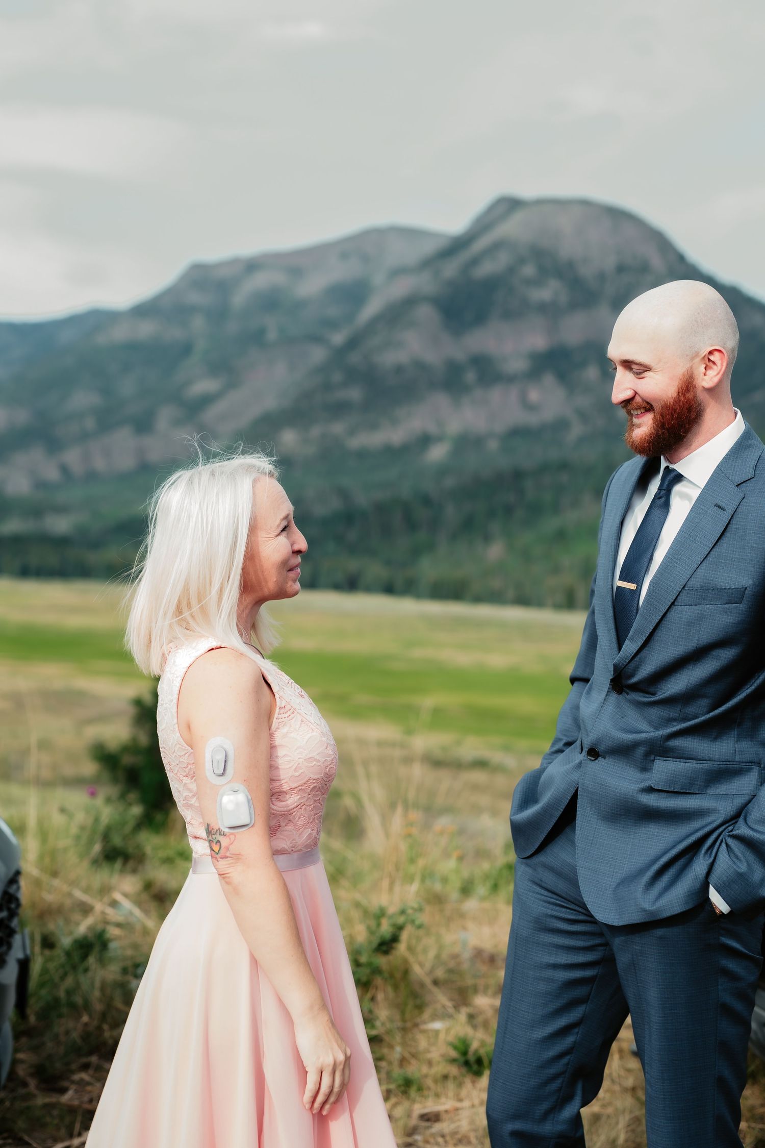 Couple sharing a lighthearted moment against dramatic mountain landscape.