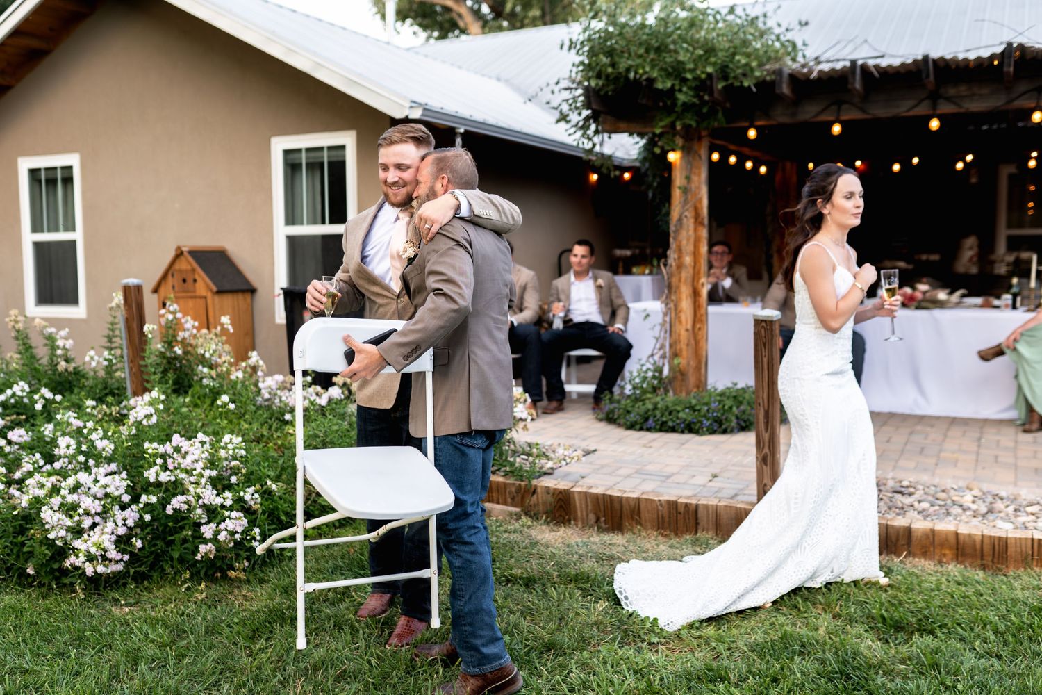 Wedding reception setup with string lights and couple in elegant attire.