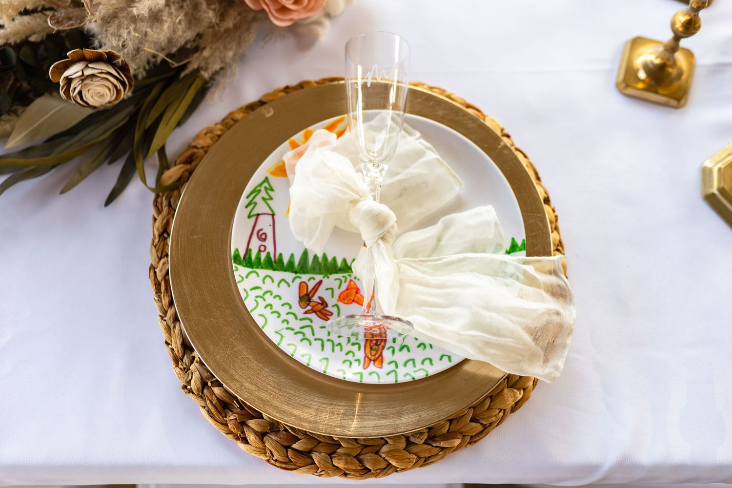 A decorative plate with a whimsical illustration on a gold-rimmed wood slice charger.