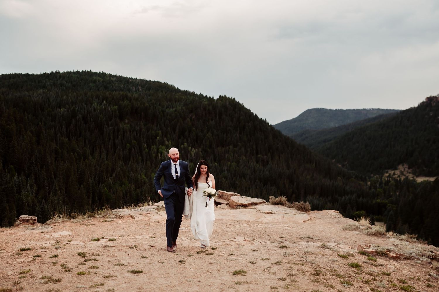 Panoramic mountain vista serves as backdrop for intimate wedding photography session.